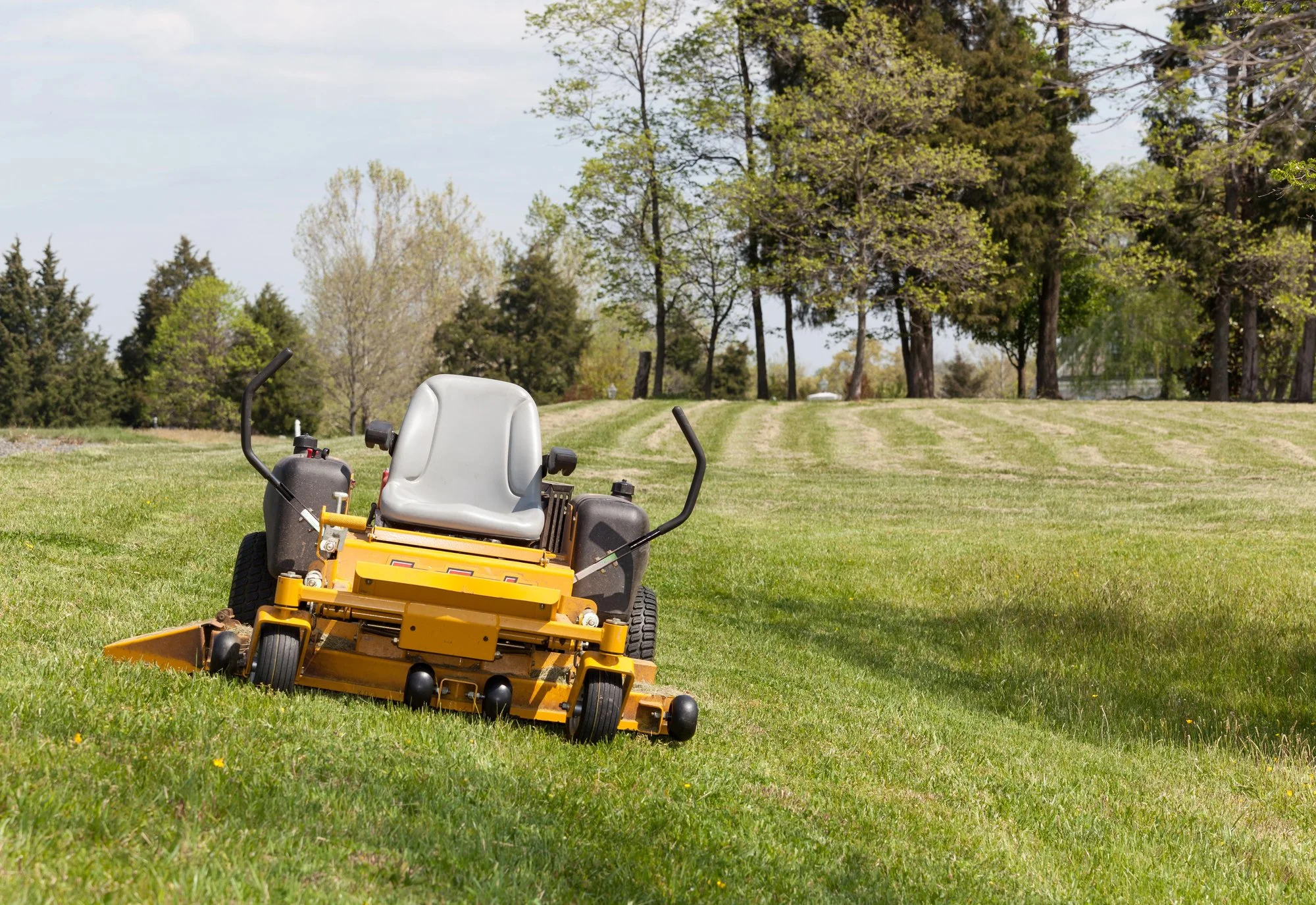 A commercial landscaping crew running a zero-turn mower has a break down.