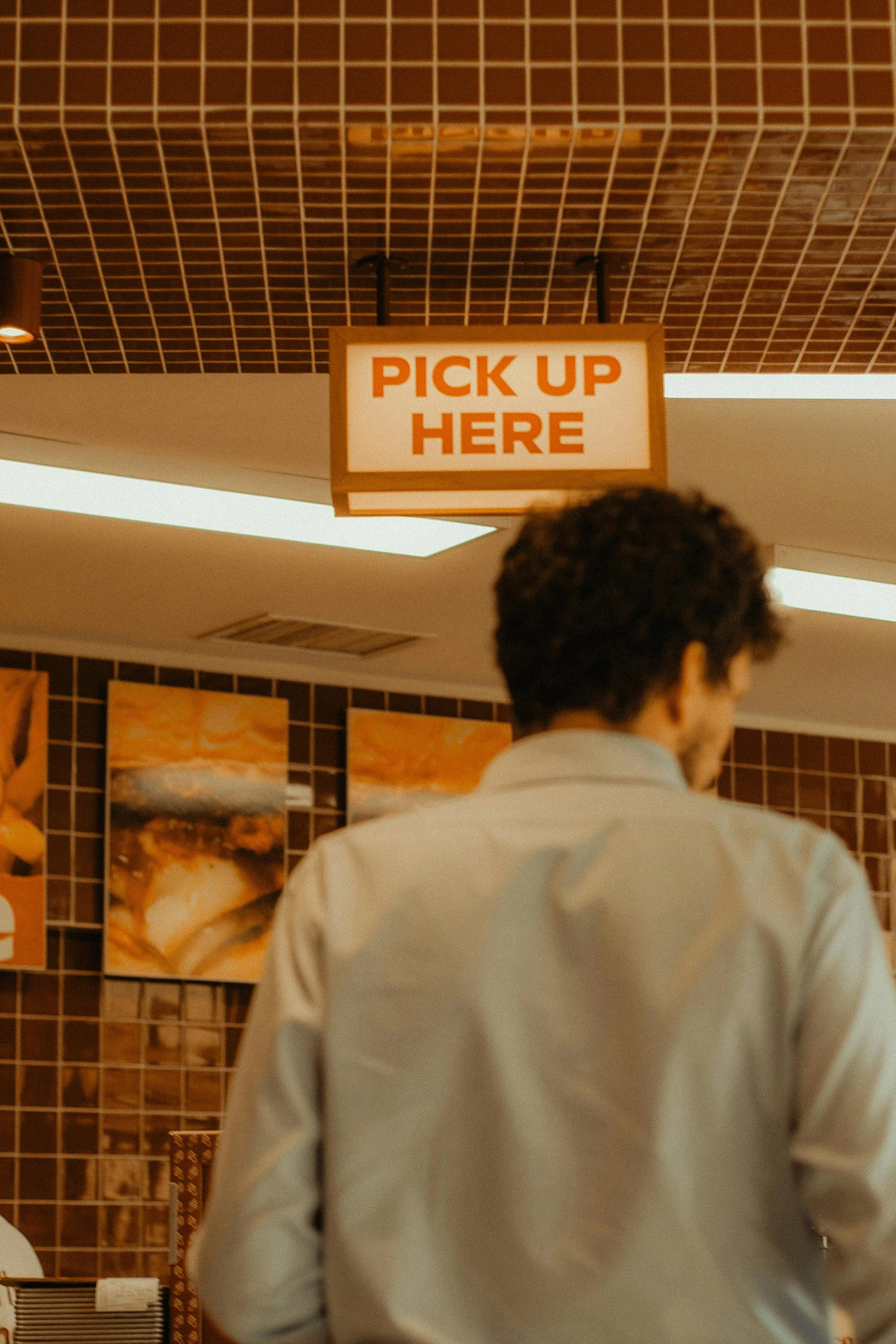 Customer standing at a restaurant pickup counter, illustrating a typical first-time visit experience.