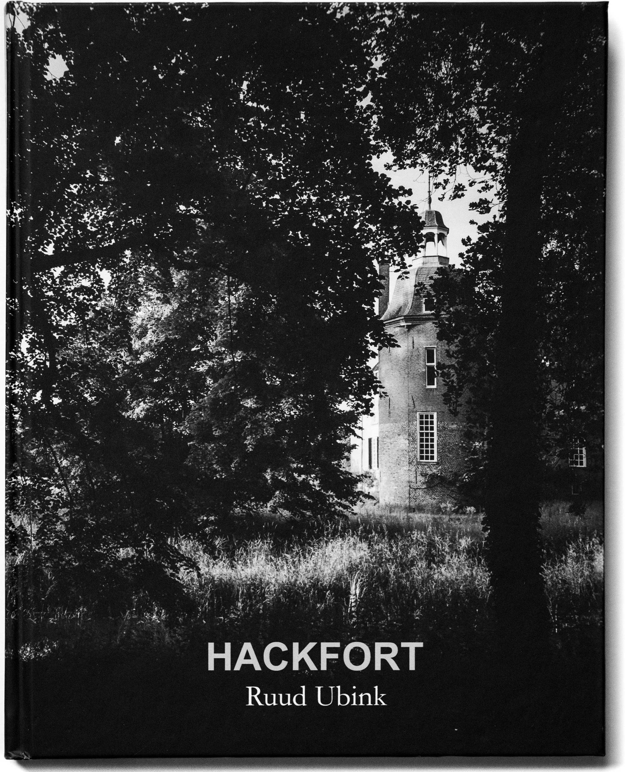Boek met donker omslag met zwart-wit foto van een kasteel en bomen, titel 'Hackfort' en auteur 'Ruud Ubink'.