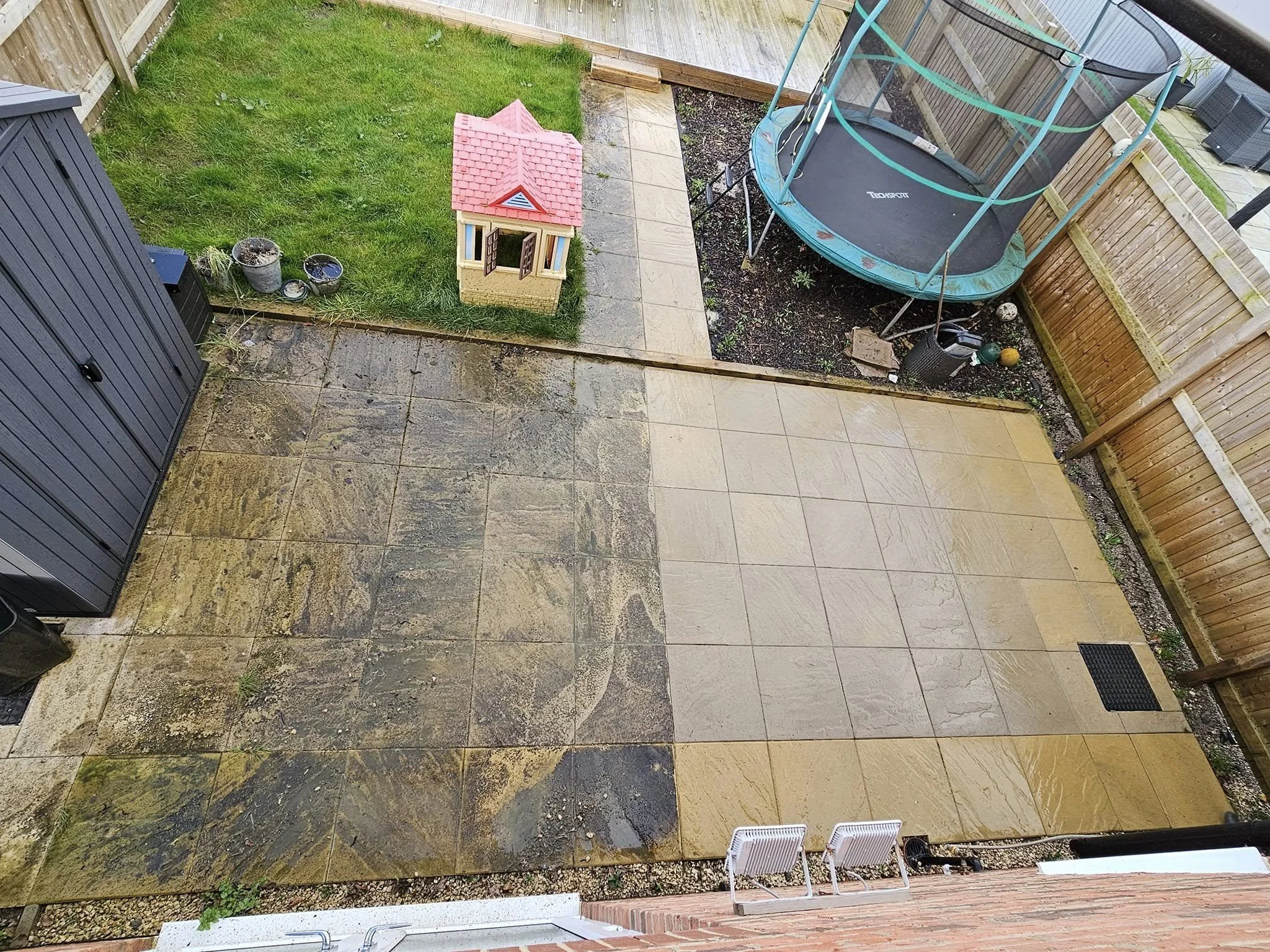 A man in rubber boots pressures washing a paved surface outdoors, with a white and blue service van in the background. a star window cleaning services.