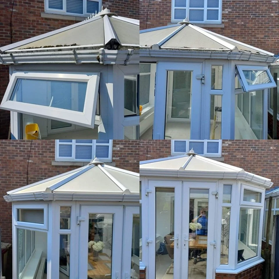 A small conservatory attached to a brick house with white frame and glass paneling, showing two open windows and a door, with some dirt or moss on the roof.