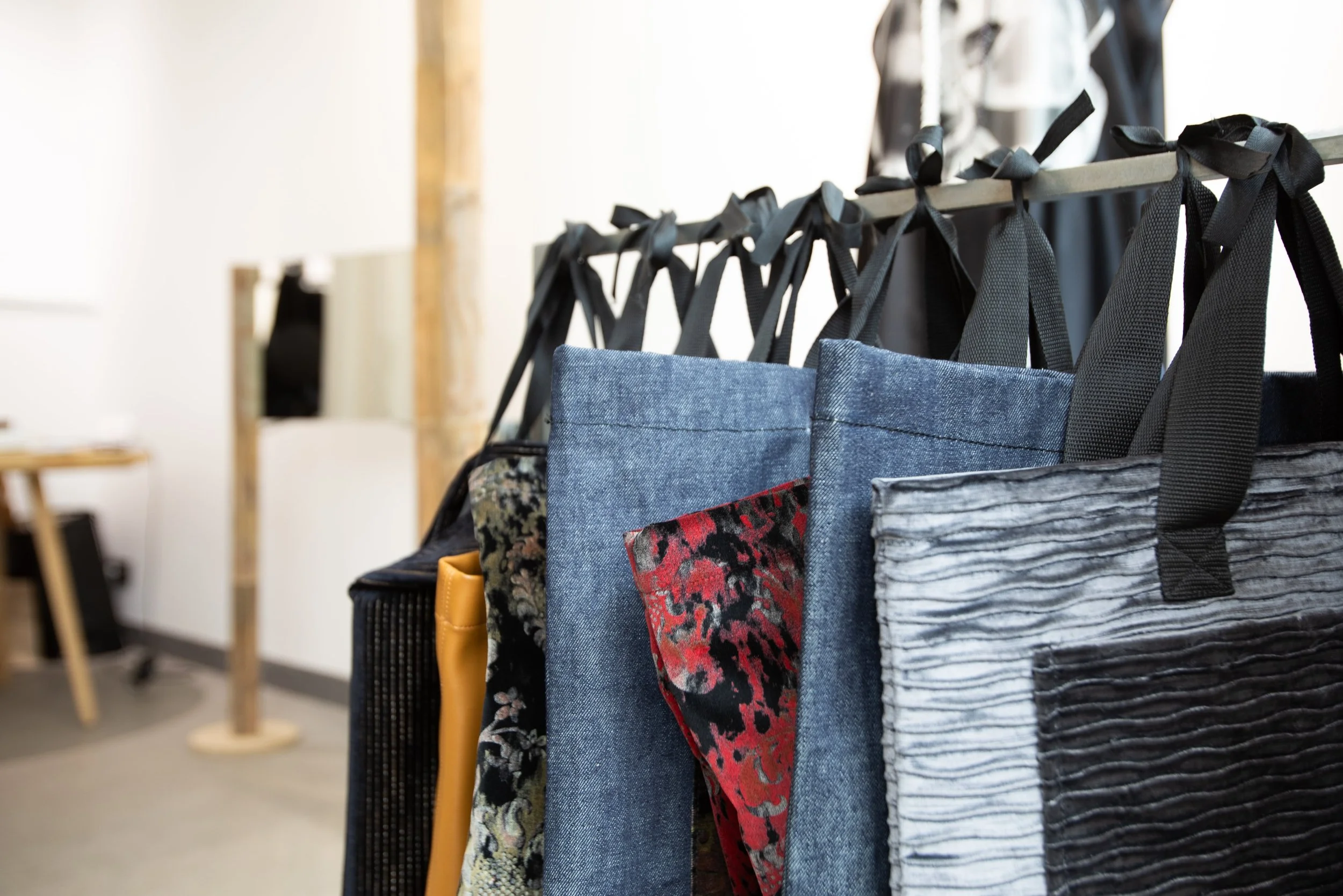 Display of various bags hanging on a rack in a retail store.