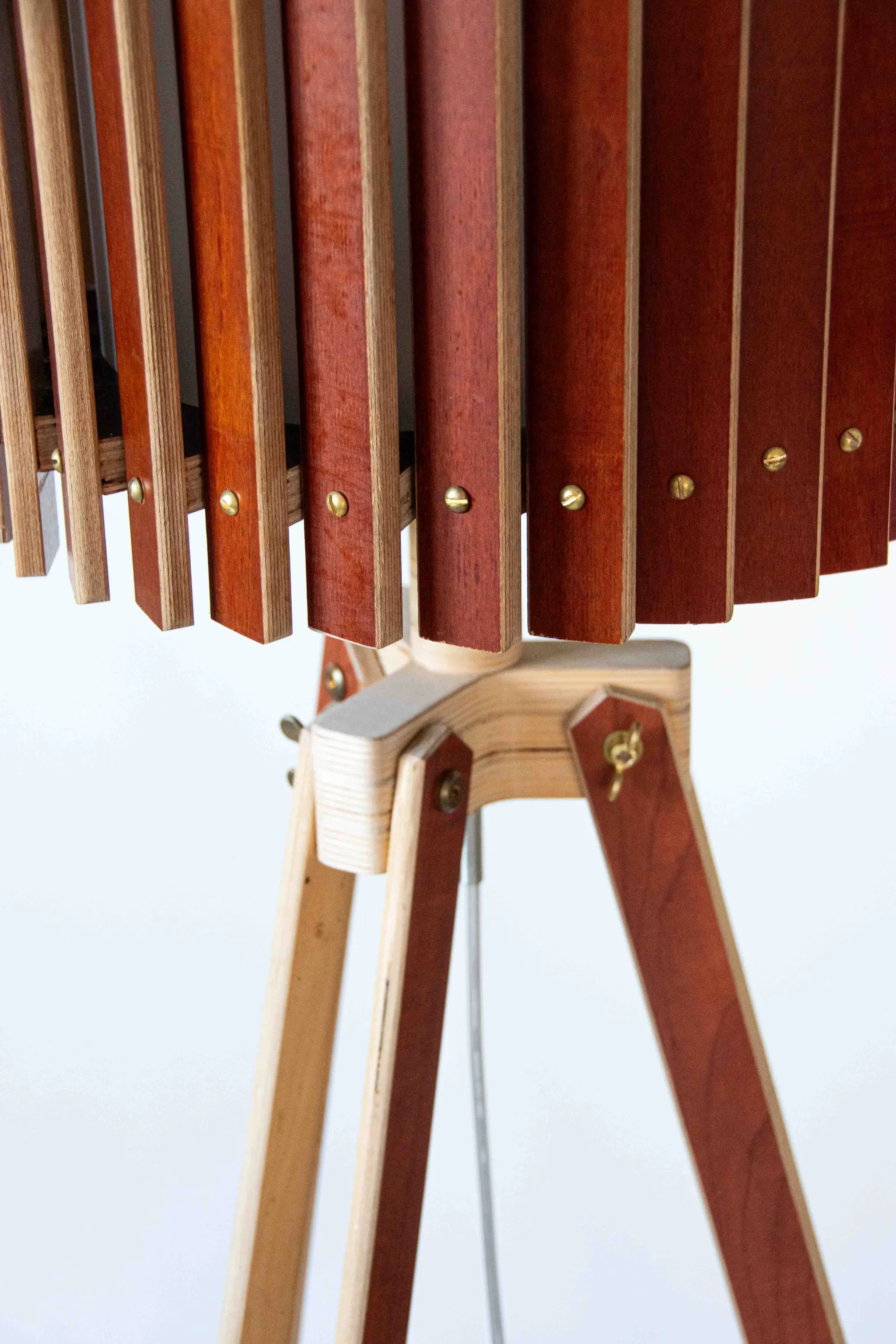 Close-up of a wooden xylophone with metal bars, mounted on a wooden stand with tripod legs.