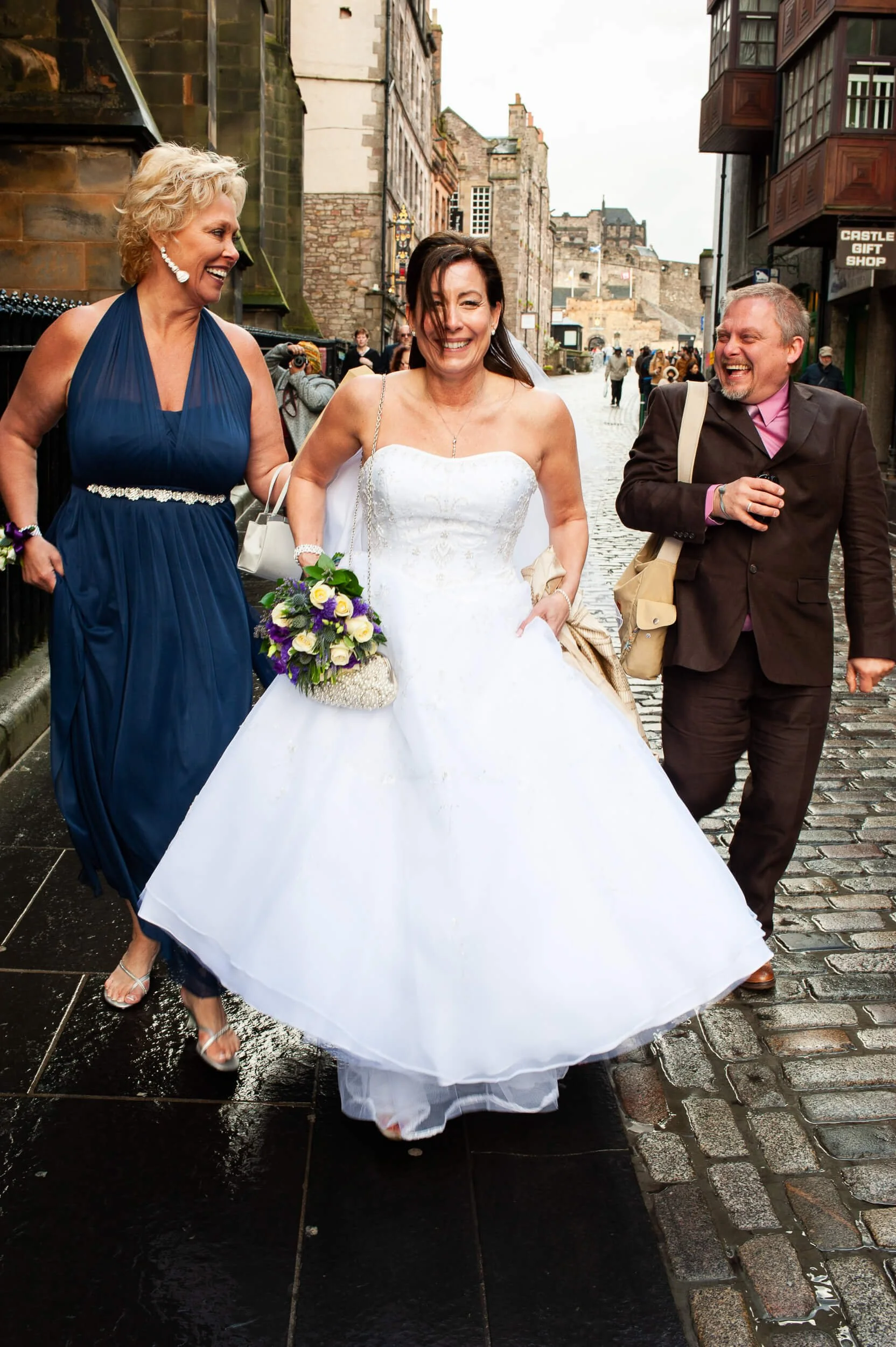 Bride walking down the Royal Mile with wedding guests after Edinburgh Castle ceremony — documentary wedding photography Scotland