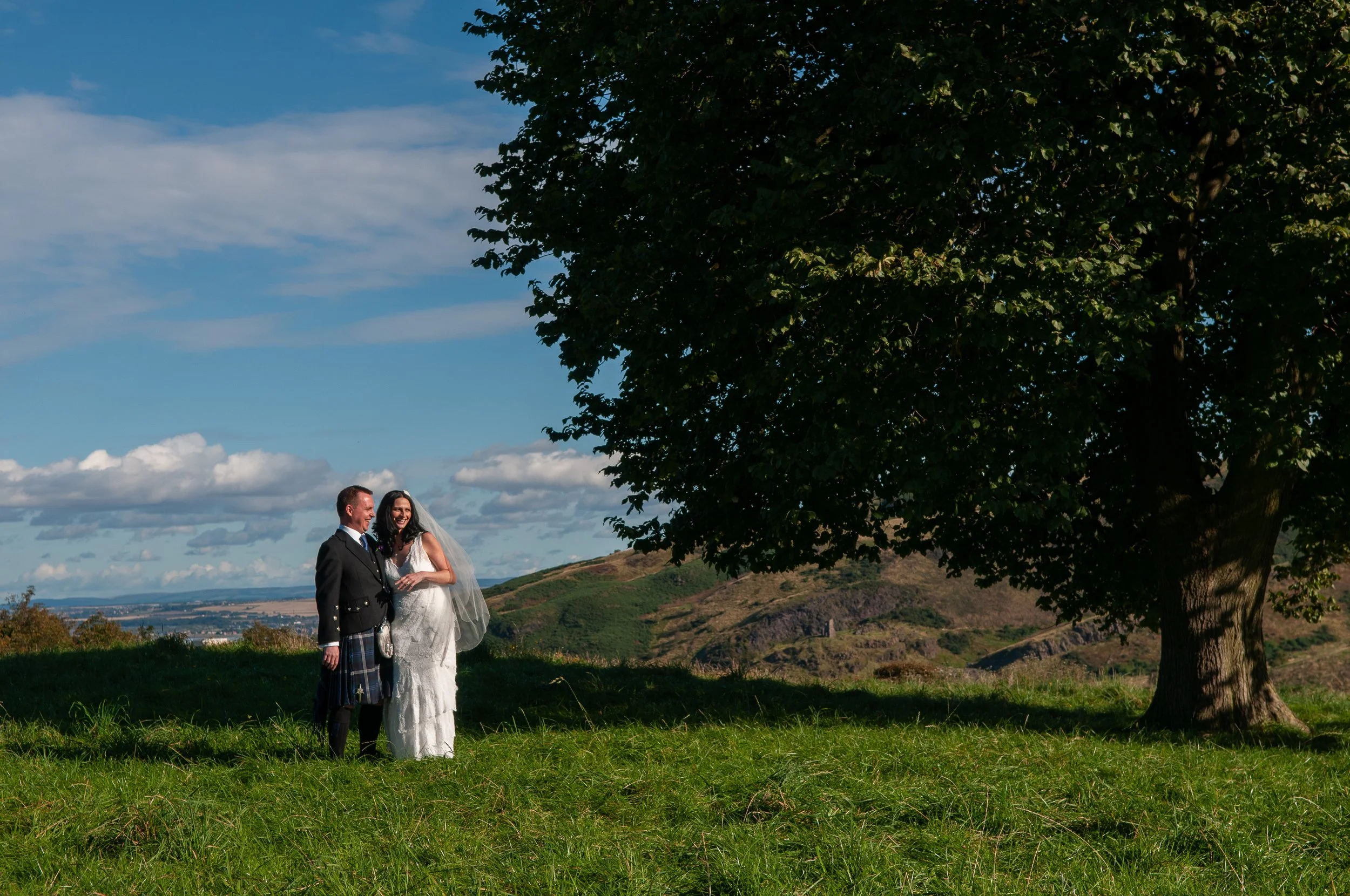 Bride and groom in kilt at Calton Hill, Edinburgh, Scotland
