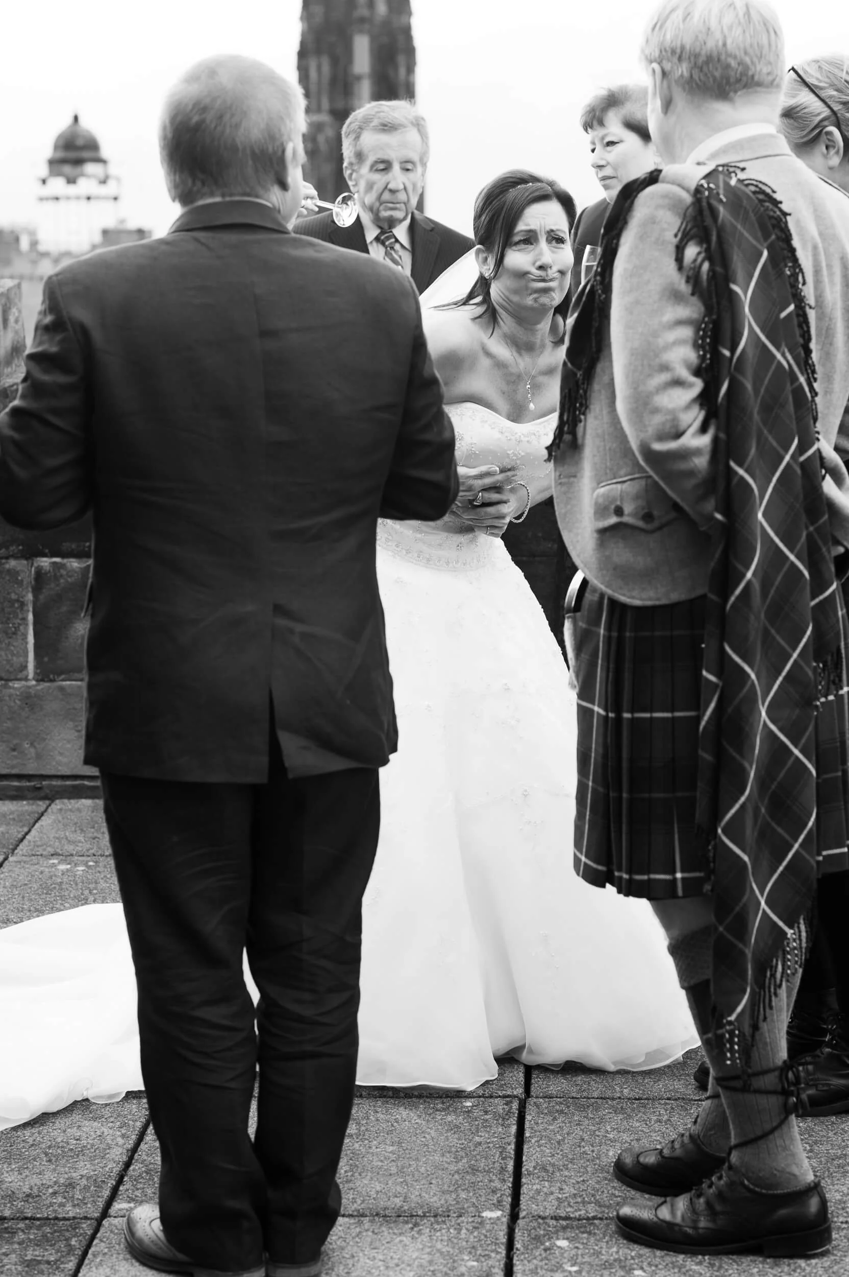 Bride overwhelmed with emotion after wedding ceremony on Edinburgh Castle ramparts — documentary wedding photography Scotland