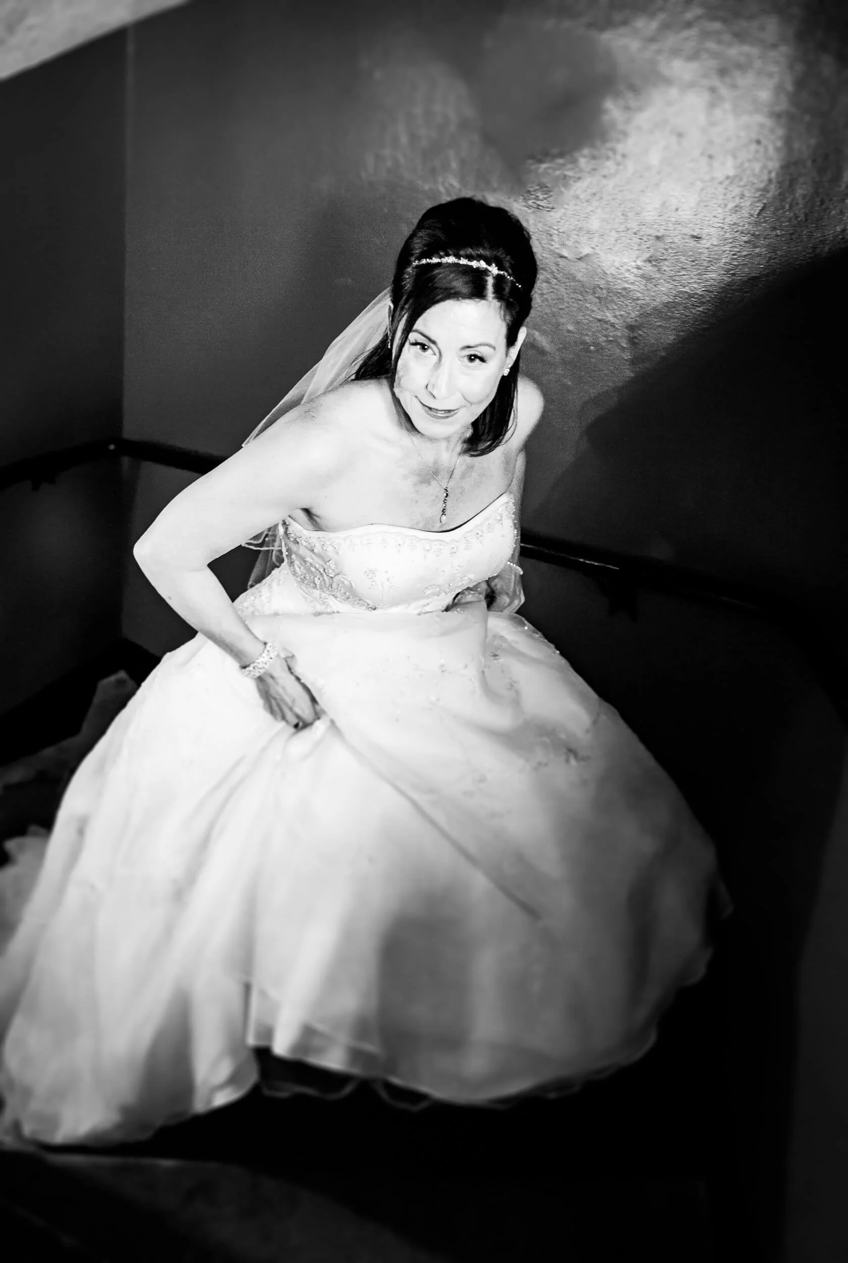 Bride on the staircase inside Edinburgh Castle — black and white documentary wedding photography Scotland