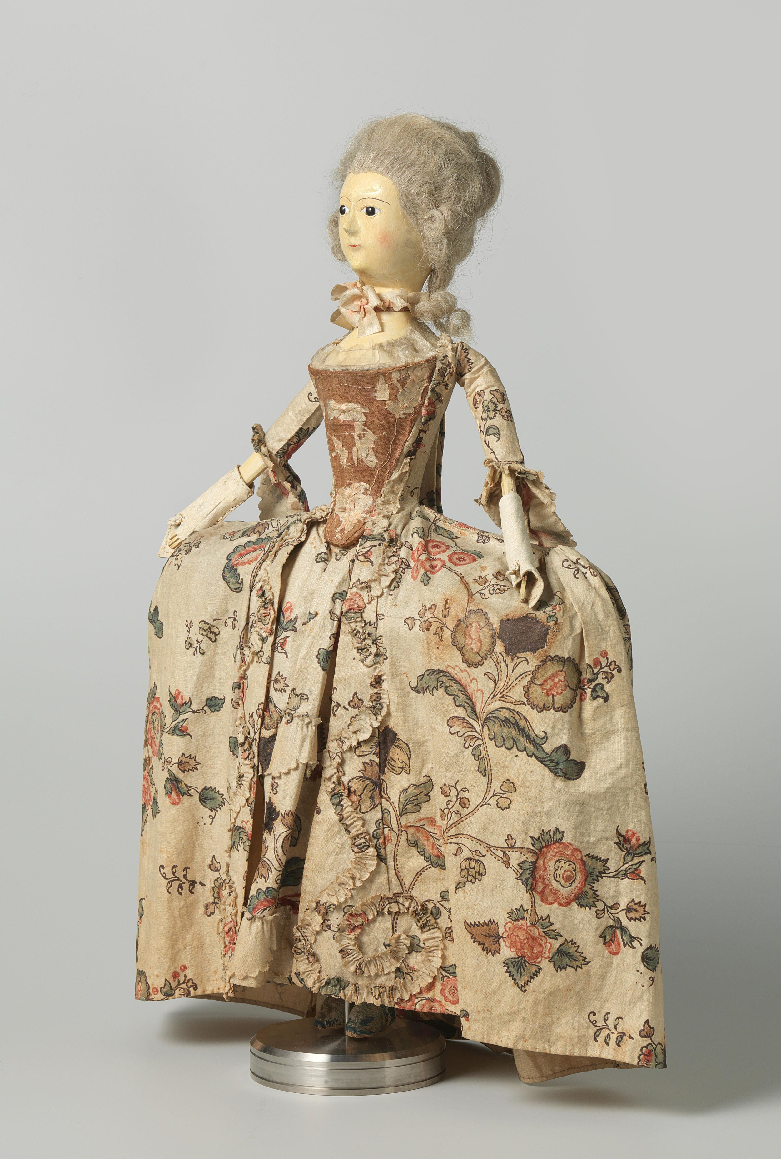 An 18th century doll, made of wood, in a floral chintz gown, made in c. 1760