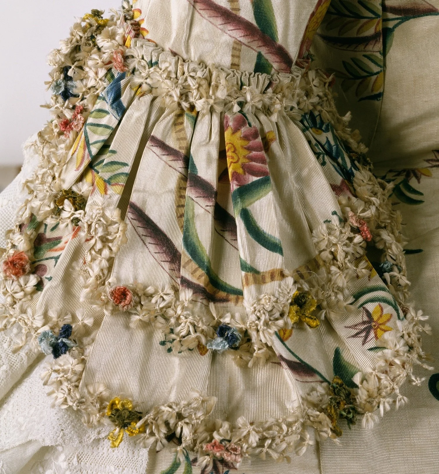 Fly fringe on the sleeve ruffle of an 18th century robe à la française (Met 1995.235a, b)