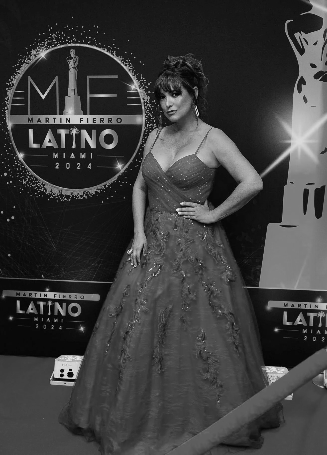 A woman in an elegant gown posing at an event for Martin Fierro Latino 2024 in Miami.
