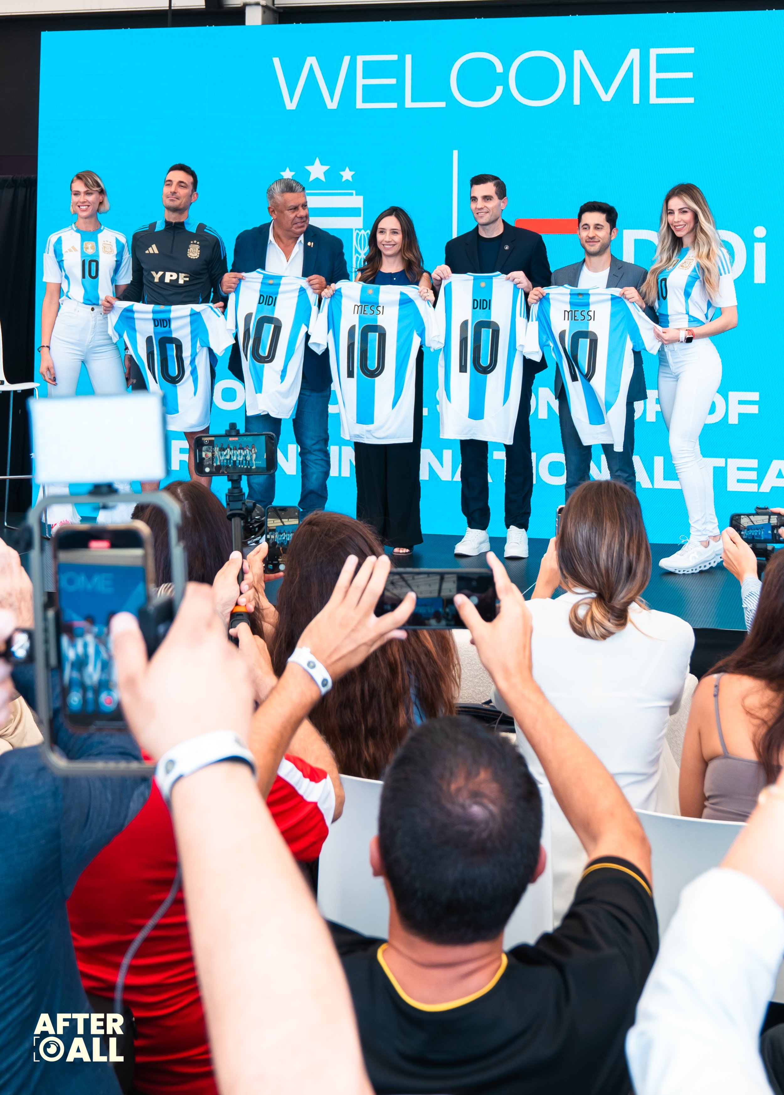 A group of people on a stage holding up soccer jerseys with the name 'Messi' and the number 10, at a welcoming event for the Argentine soccer player.