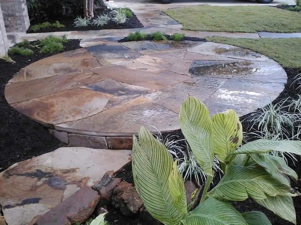 Stone patio with large rocks and a grassy yard in the background.