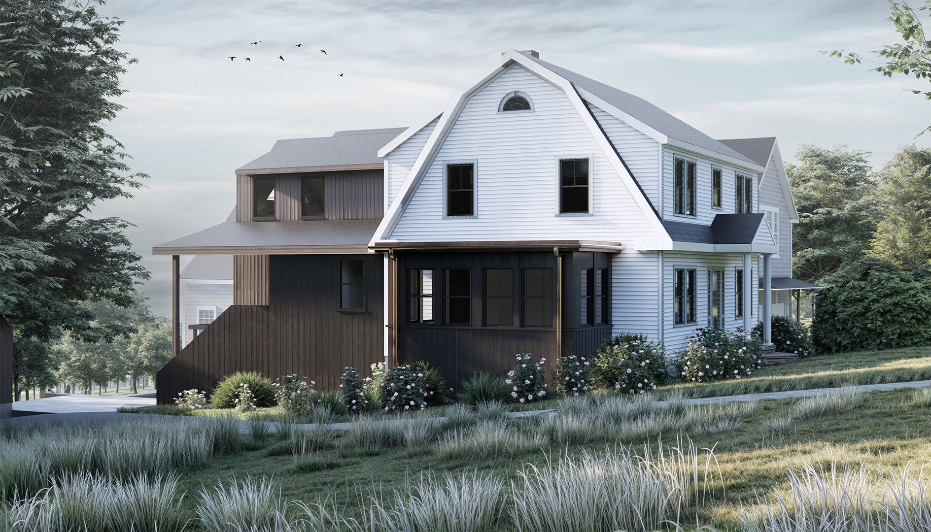 A modern two-story house with white and black exterior siding, situated on a grassy lawn with shrubs and flowering plants. The house has multiple windows, a gabled roof, and a porch area, surrounded by trees and under a partly cloudy sky.
