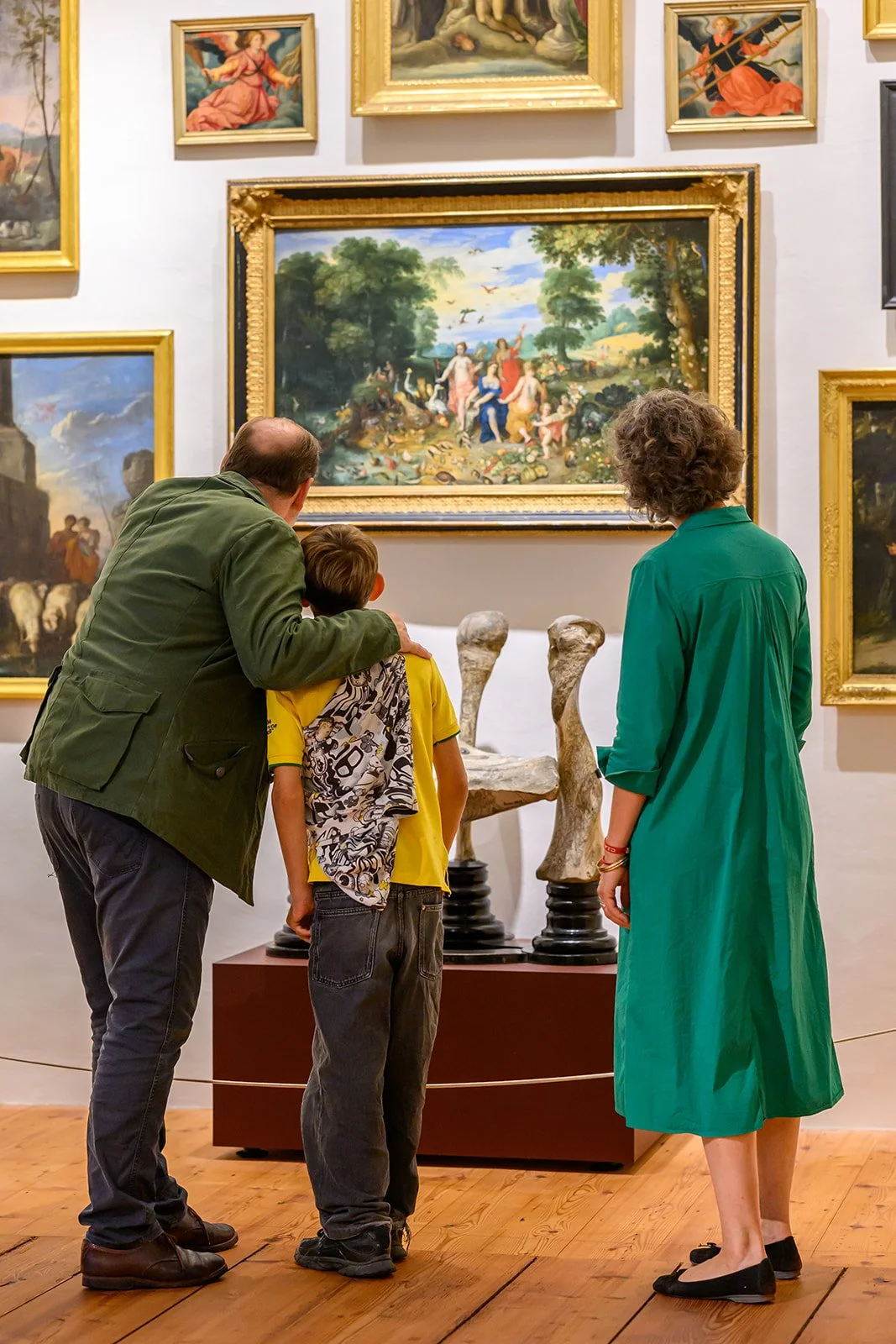 Familie betrachtet Jan Brueghels „Vier Elemente“ und den Elefantenstuhl in der Wunderkammer von Stift Kremsmünster