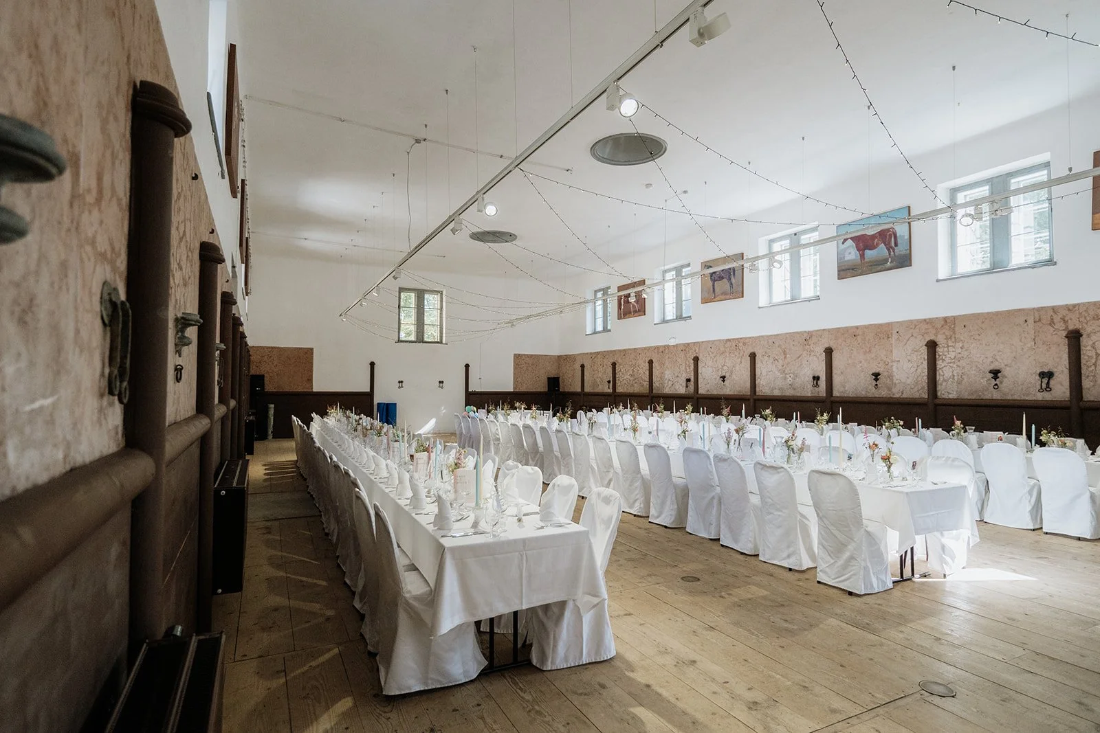 Innenansicht Kaiserliche Stallungen Bad Ischl mit festlich gedeckten Tischen – Hochzeit im Salzkammergut