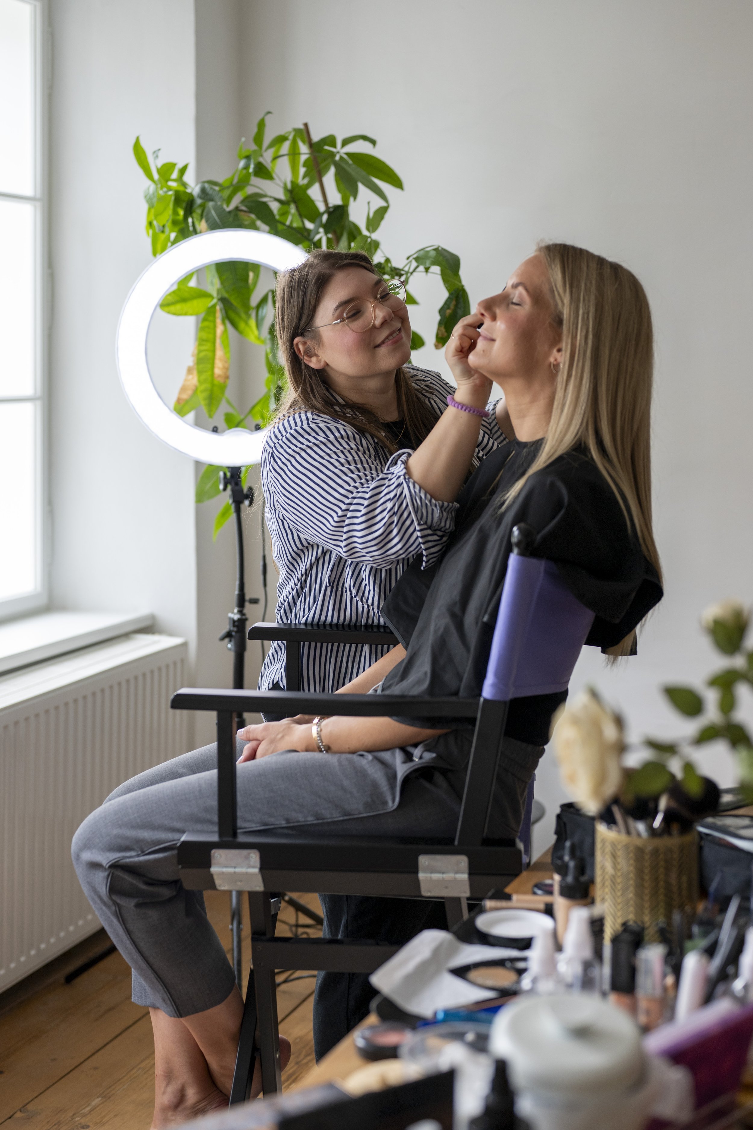Visagistin beim Schminken einer Kundin – professionelles Make-up für ein Fotoshooting