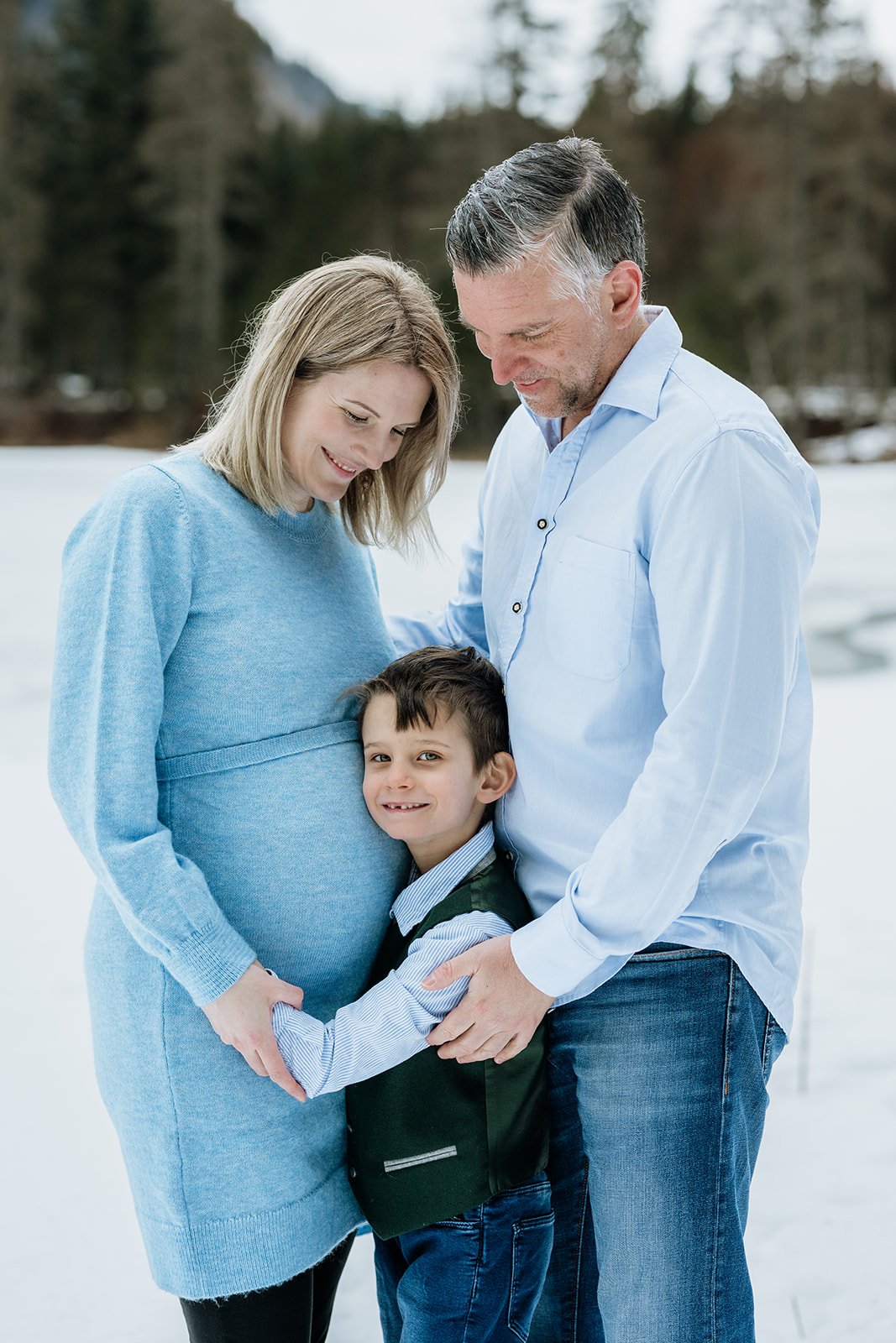 Familie umarmt sich im Hintergrund ist winterliche Landschaft zu sehen