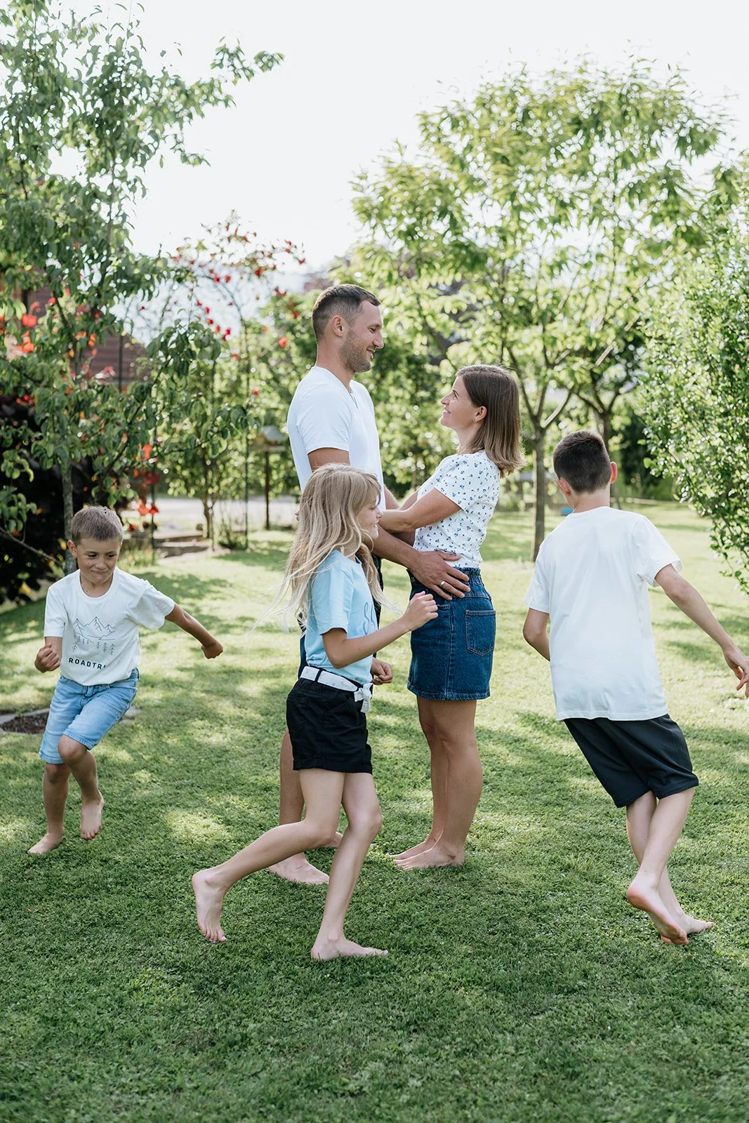 Lebendiges Familienshooting im Garten – Kinder spielen bei der Familienfotografie im Freien