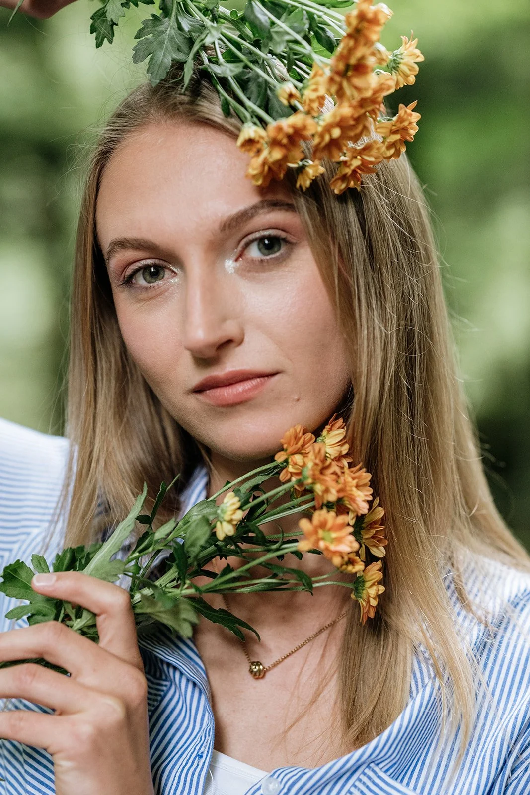 Frau mit Blumen im Haar und in der Hand, im Grünen, nahaufnahme