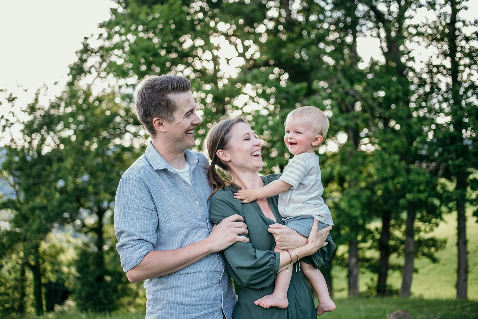 Familienfotografie im Freien – glückliche Familie mit Kind bei einem Familienshooting