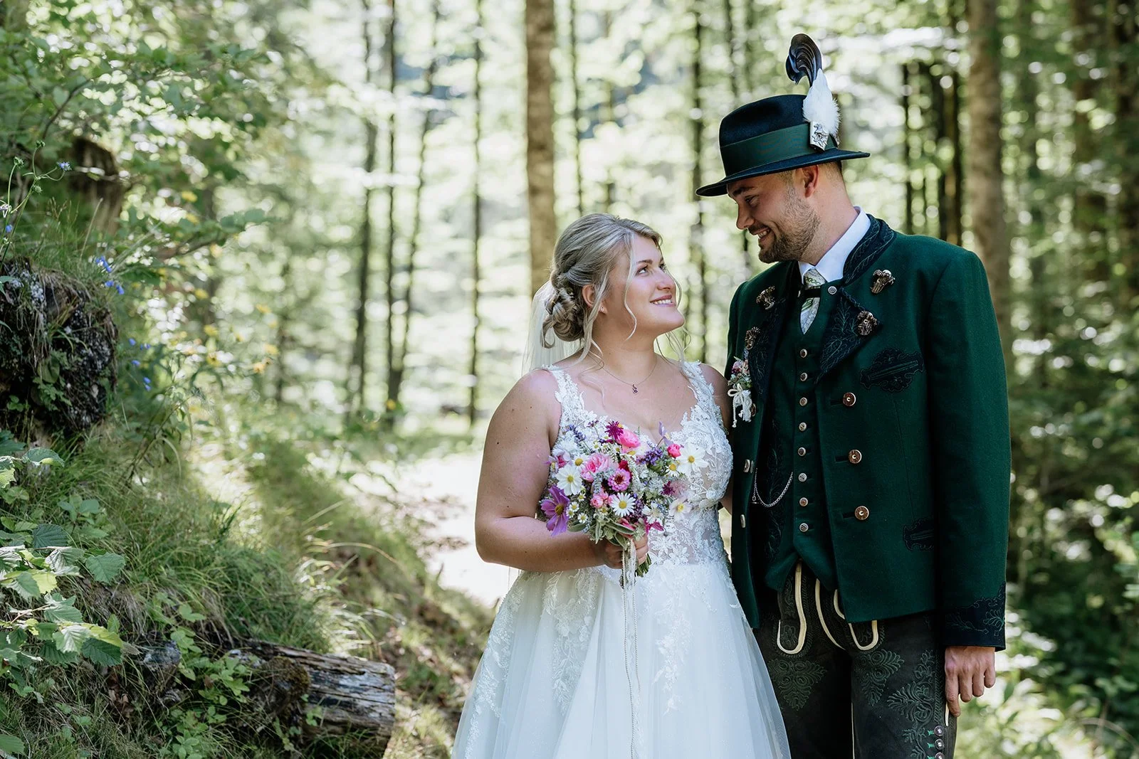 Verliebtes Brautpaar in Tracht blickt sich romantisch an. Hochzeitsfotograf Bad Goisern