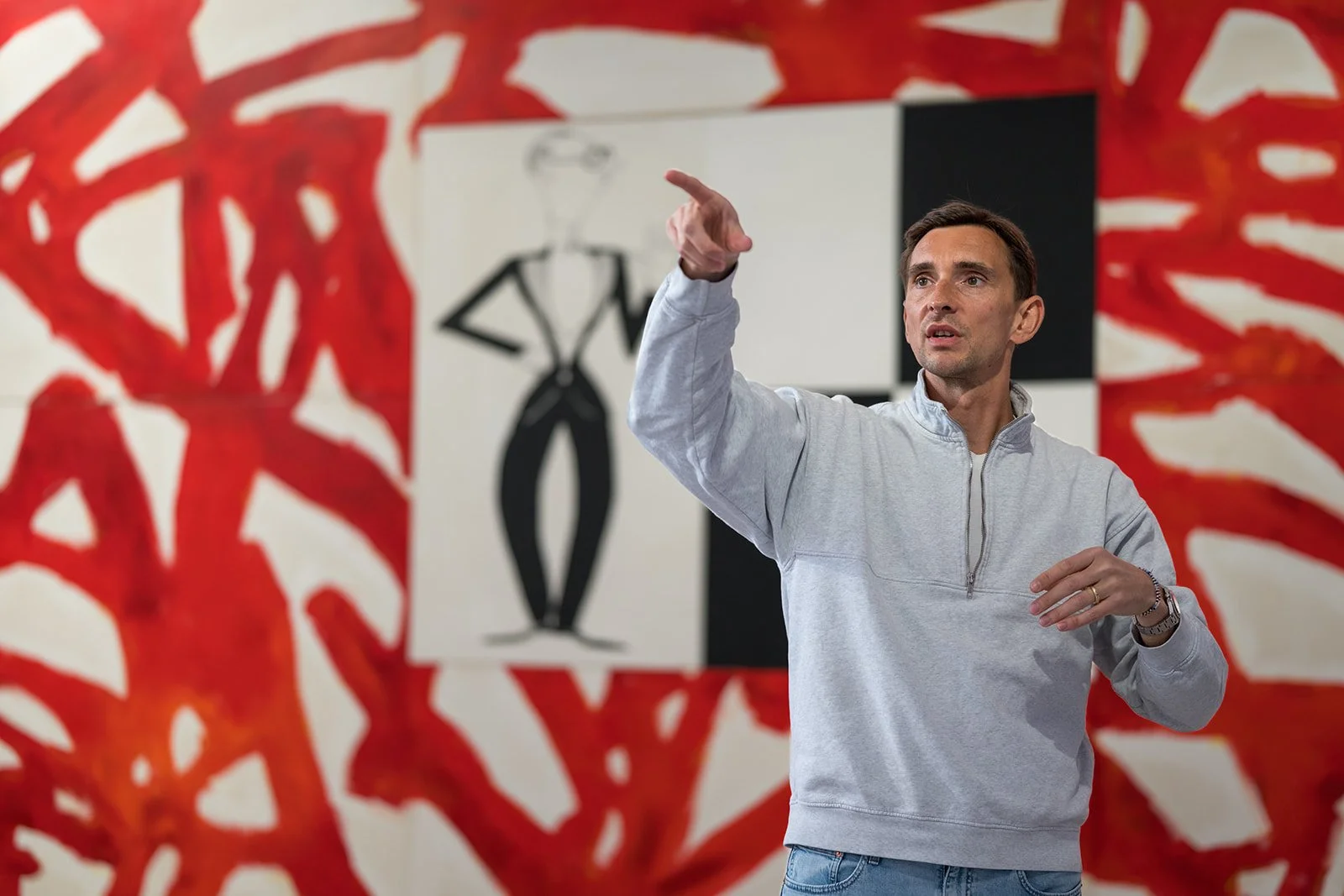 Mann erklärt in einem Raum mit moderner Kunst an der Wand.