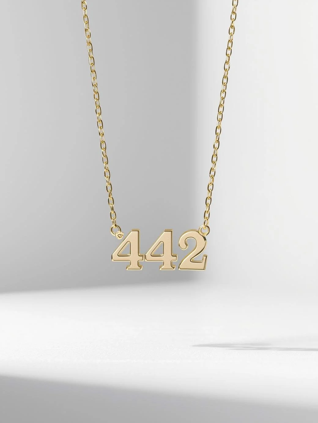 Gold Necklace with number 442 on the chain. product image simple necklace the font is connected numbers 442 (2).jpg