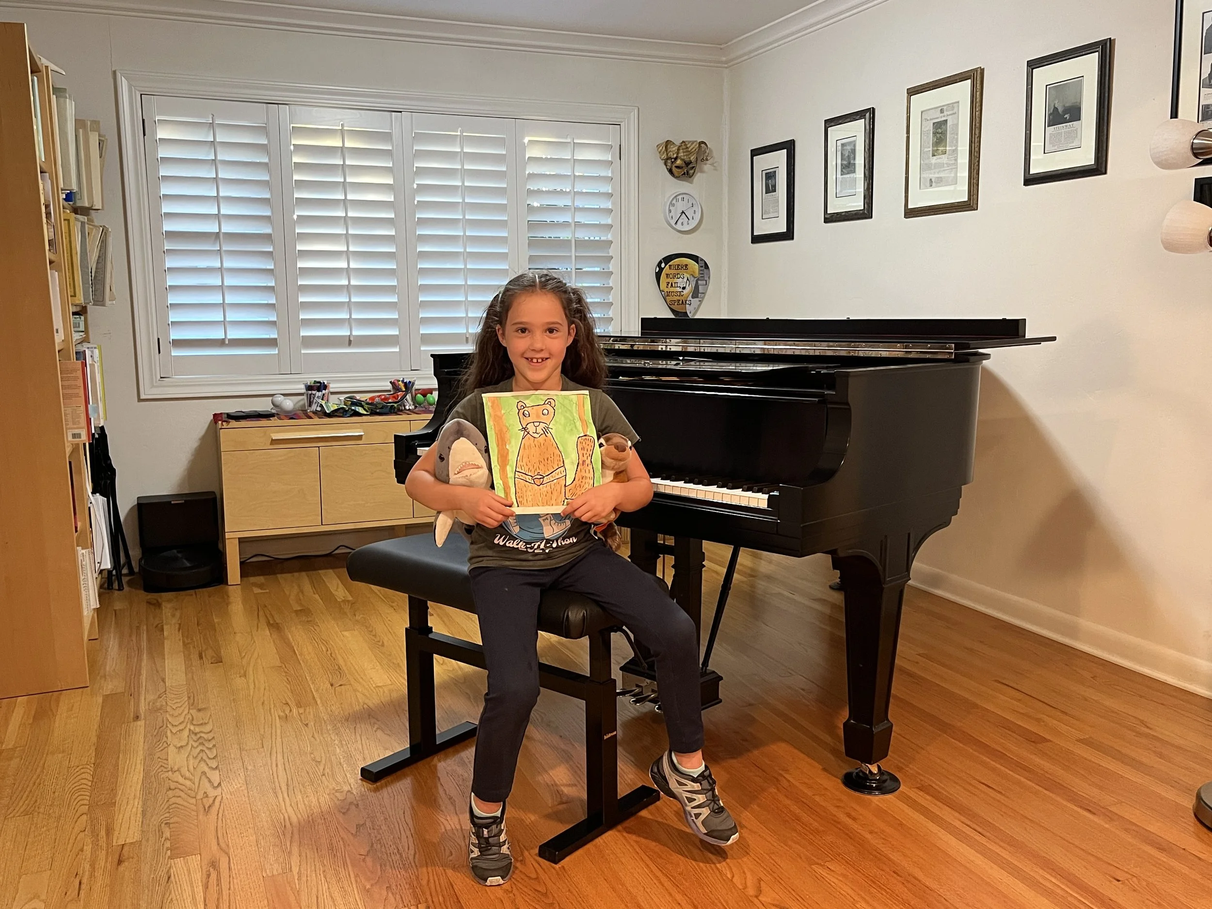 Smiling girl sitting at black piano