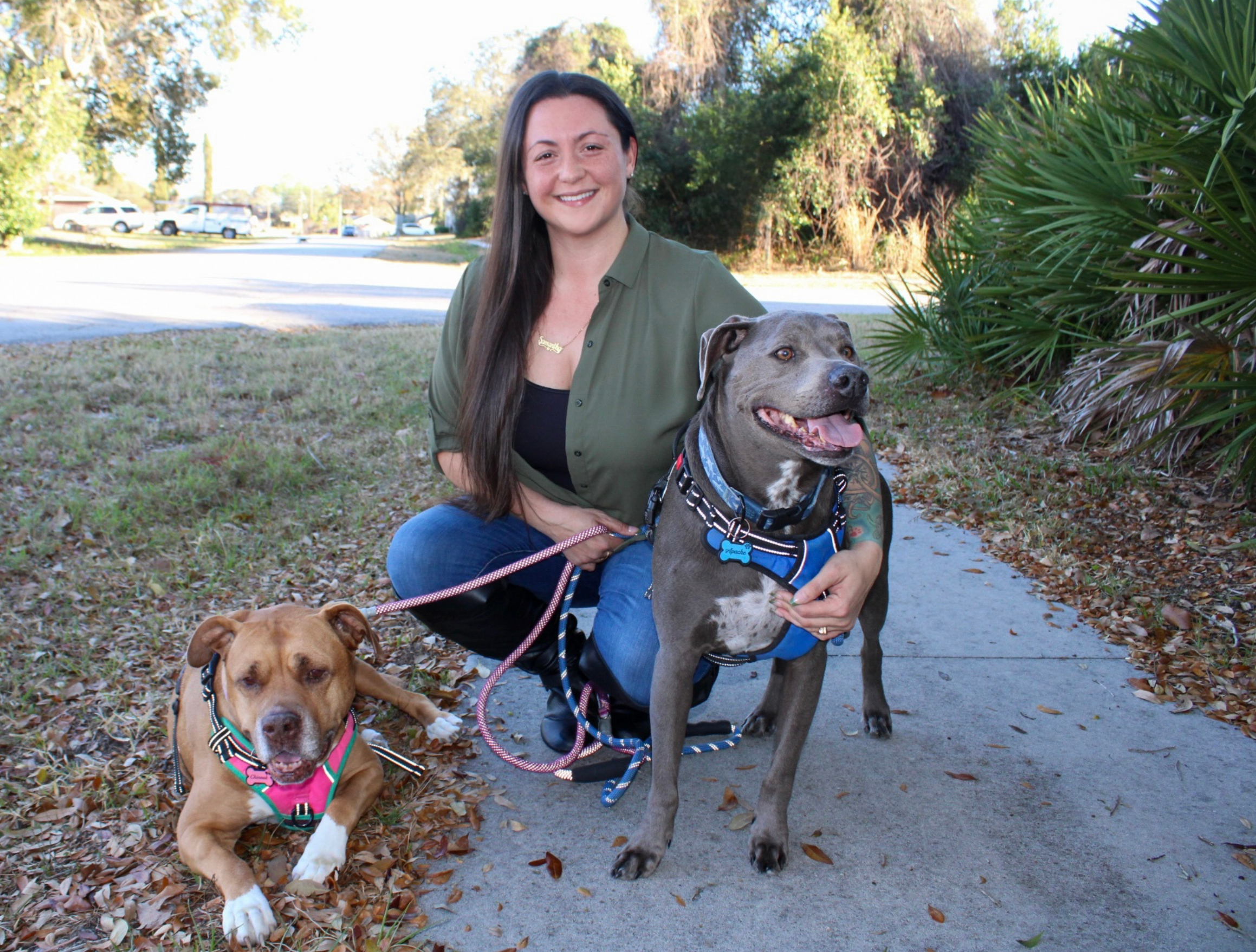 Samantha Gagliardi, founder of Pits & Prints, posing with her pit bulls Chinook and Apache, the dogs who inspired her advocacy and apparel brand.