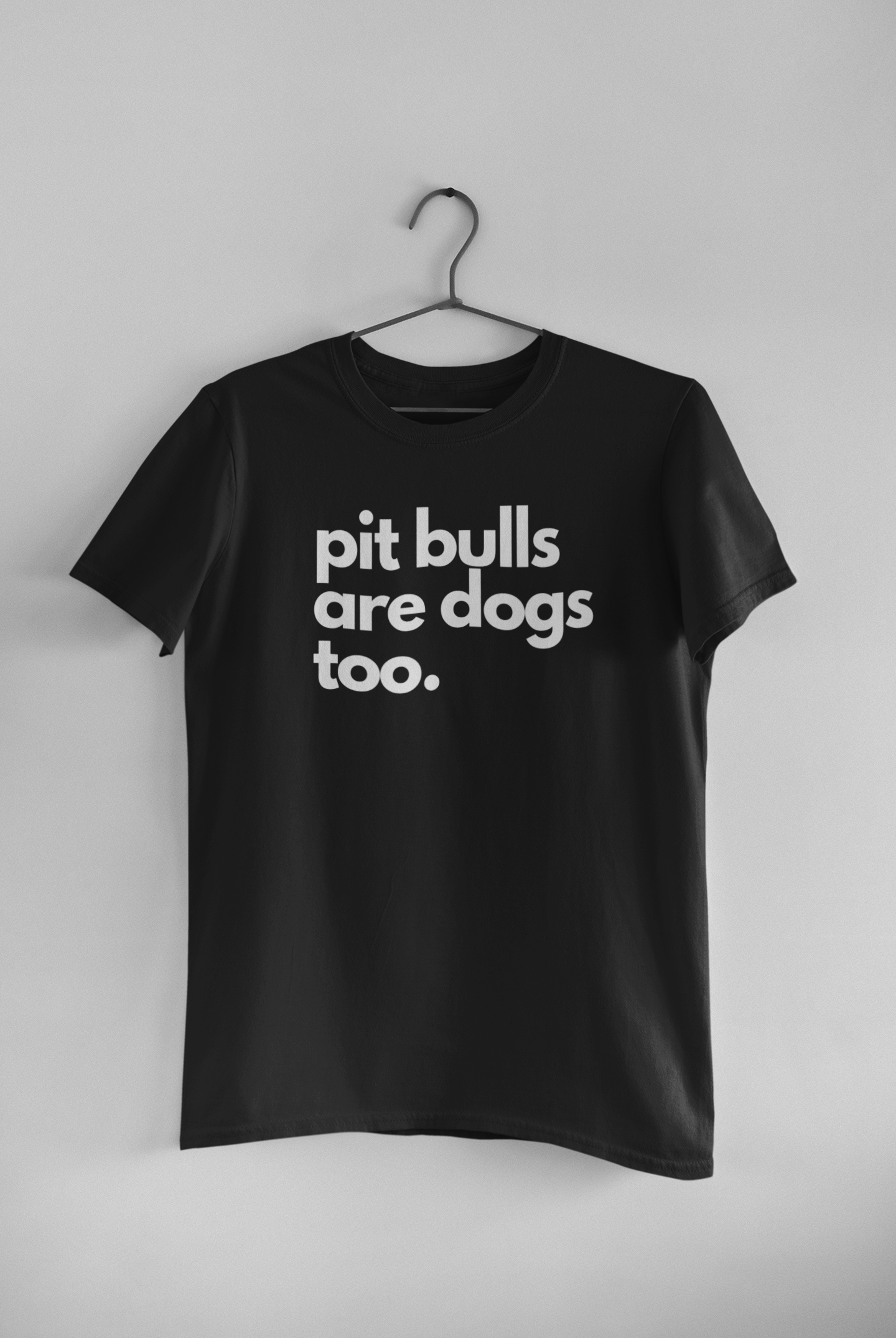 Black t-shirt featuring bold white typography reading "Pit Bulls Are Dogs Too." A minimalist pit bull advocacy design promoting education, compassion, and breed awareness.
