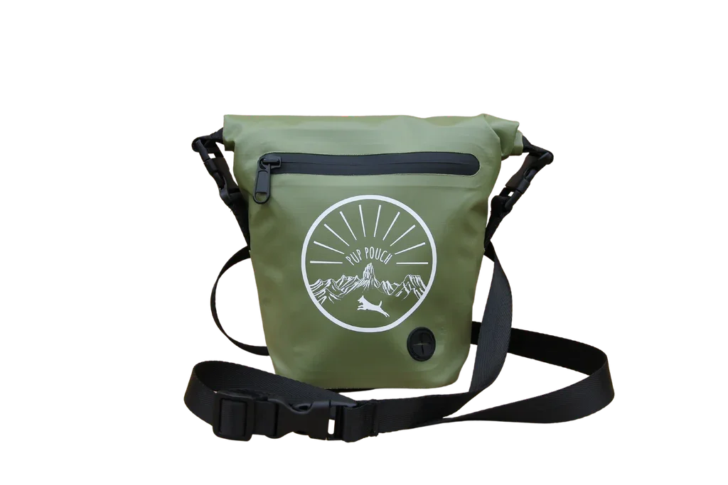Green waterproof bag with a black zipper and adjustable strap, featuring a white circular logo with mountains, a sun, and a running dog, and labeled ‘Pup Pouch’.