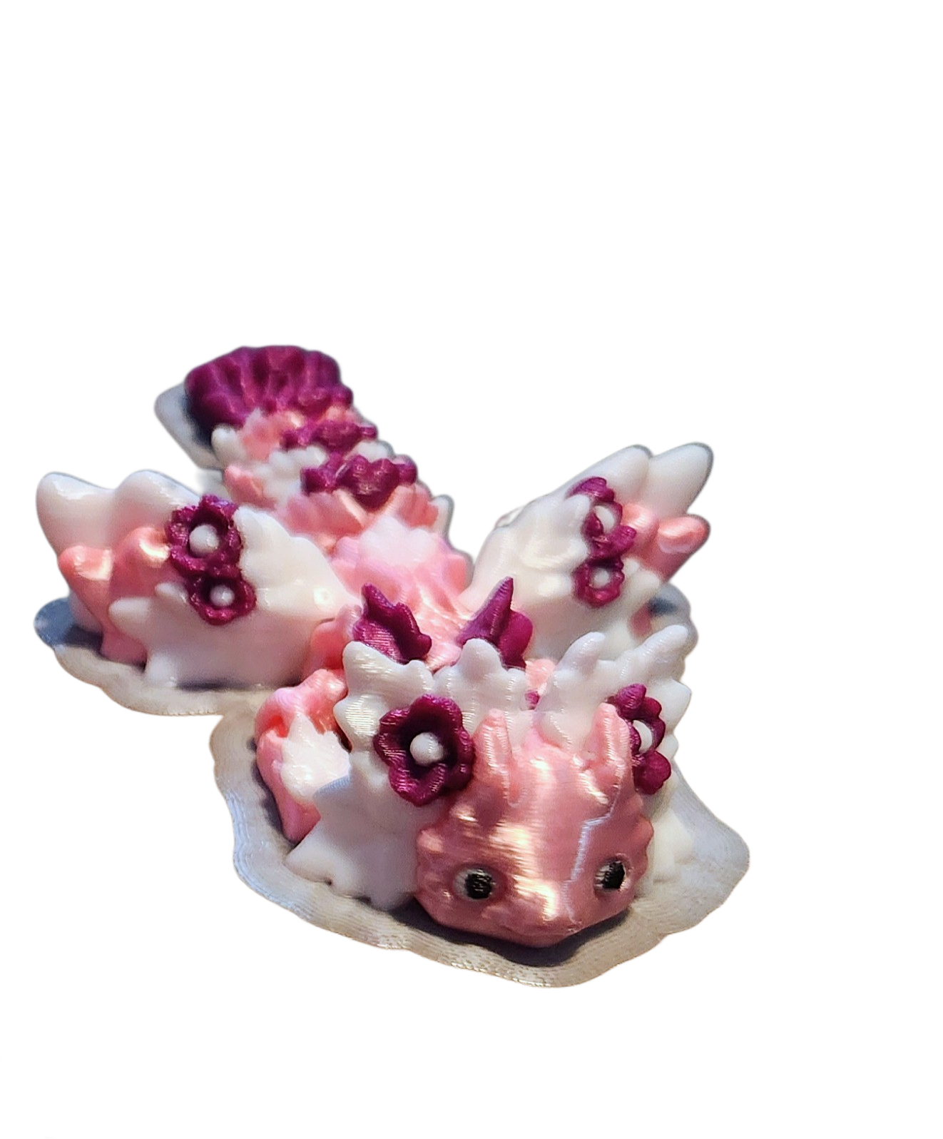 Decorative ceramic figurine of a pink and white whale with floral accents, resting on a shell-shaped base.