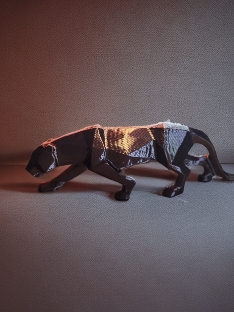 A black and gold geometric sculpture of a panther walking