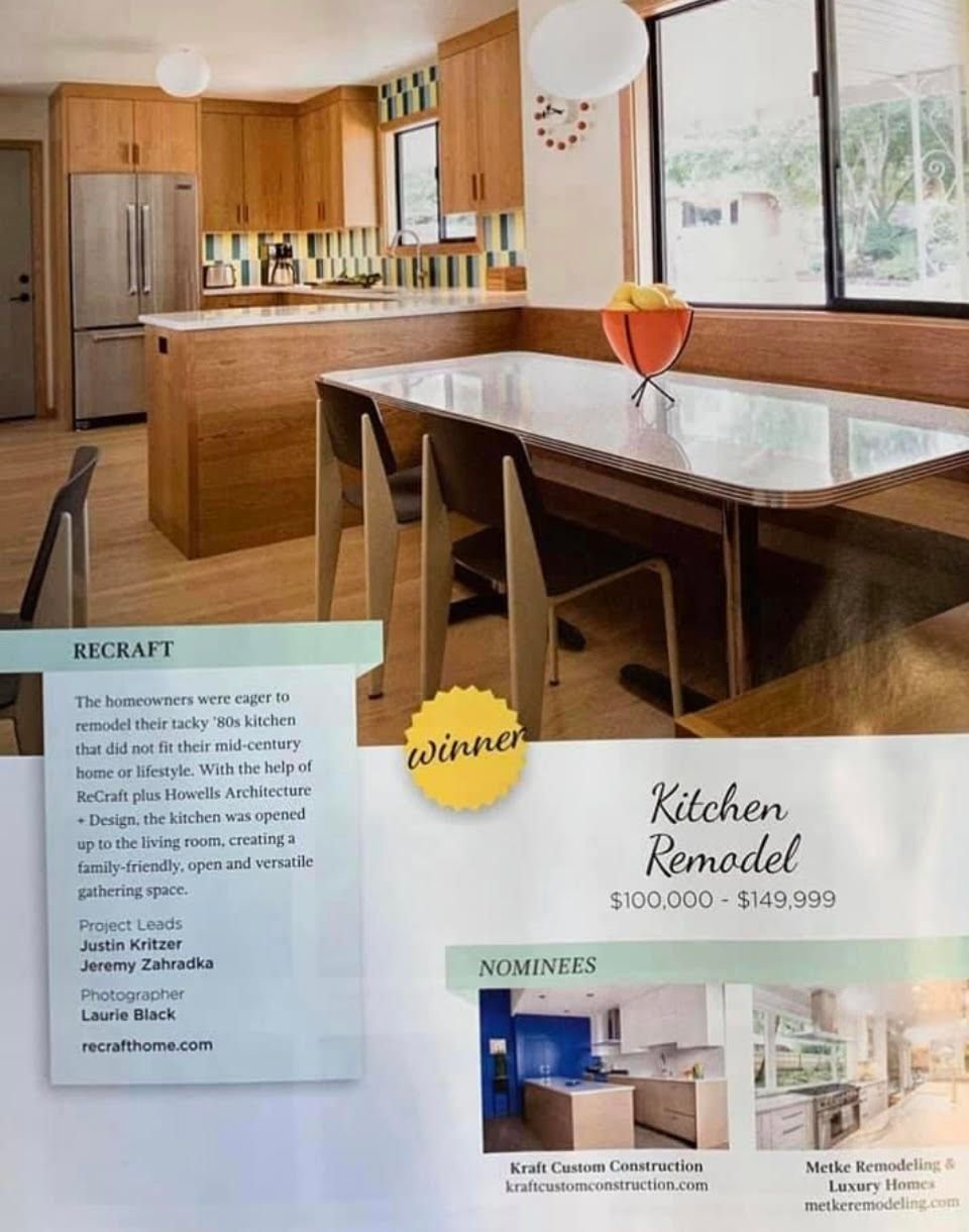 Photo of a kitchen remodel project with a modern wooden kitchen, large window, and a dining table with a fruit bowl. Text on a card indicates it's a winning project in a home renovation contest.