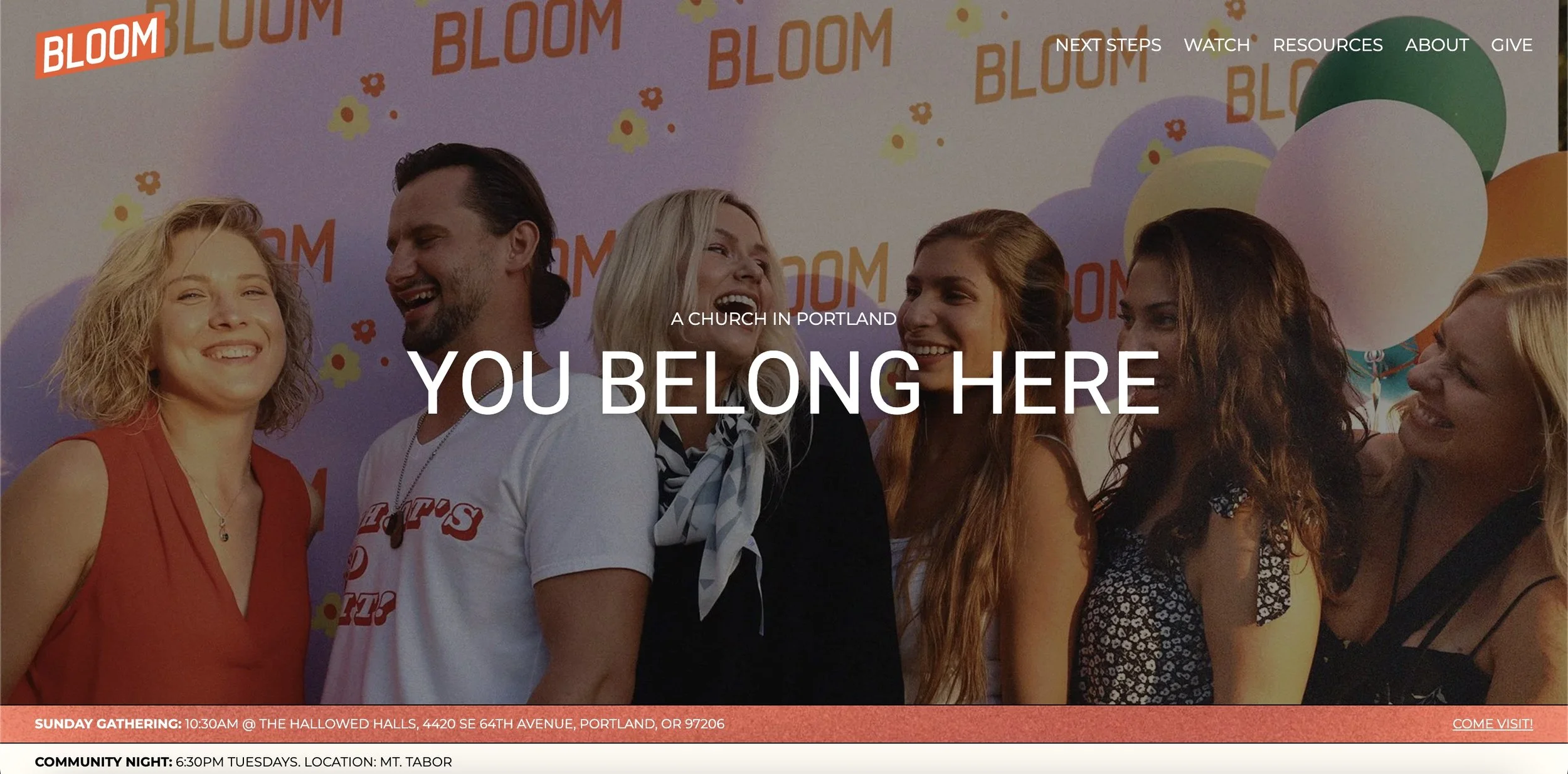 A group of six smiling adults standing together at a church event in Portland, with colorful balloons and a purple backdrop that says 'BLOOM' in the background. The webpage headline reads 'YOU BELONG HERE'.