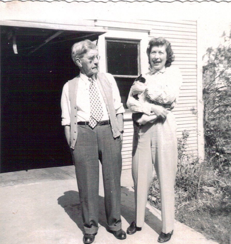 Unknown guests in front of carriage house featuring an overhead garage door.