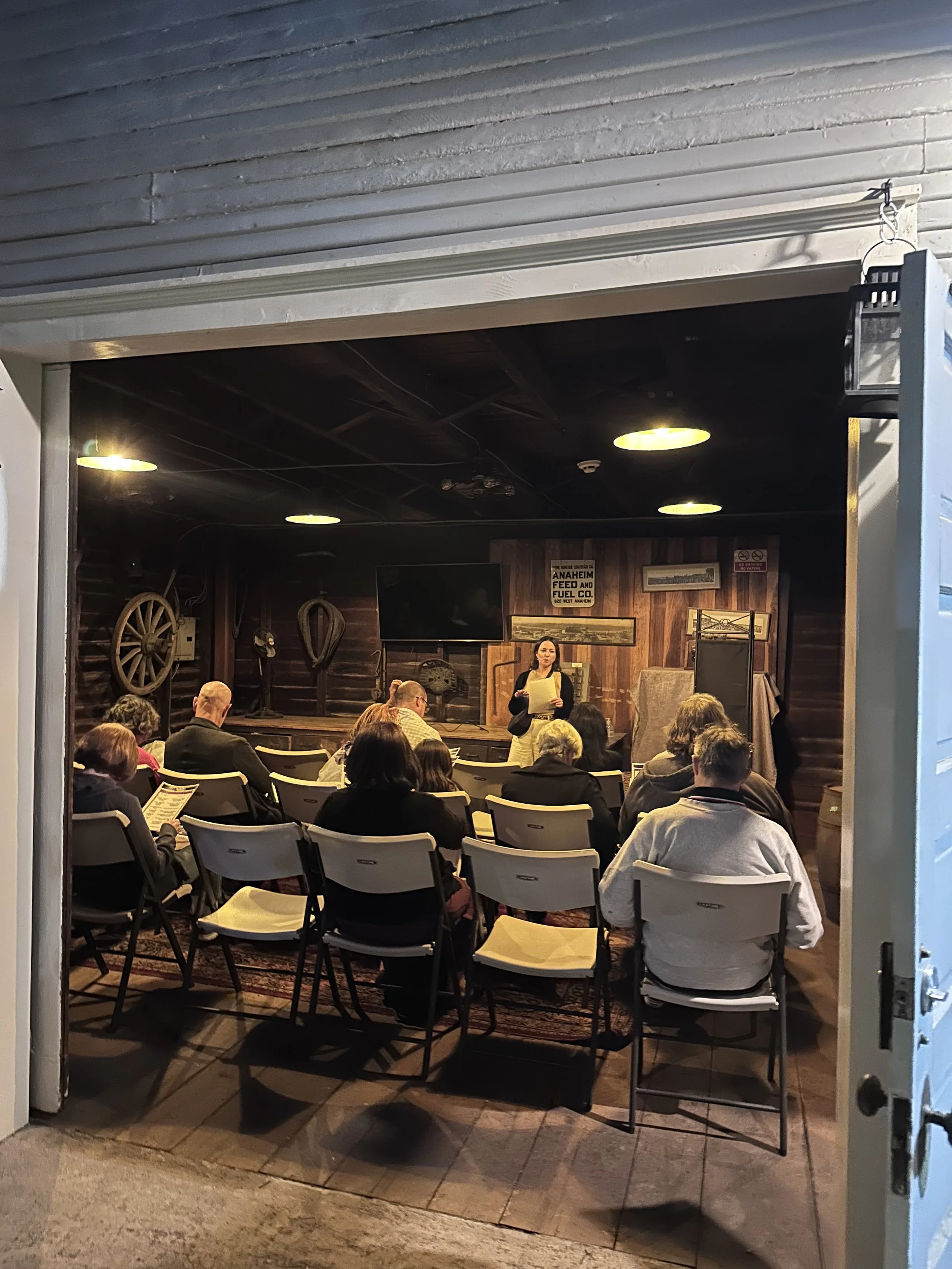 People sitting inside the carriage house having a meeting