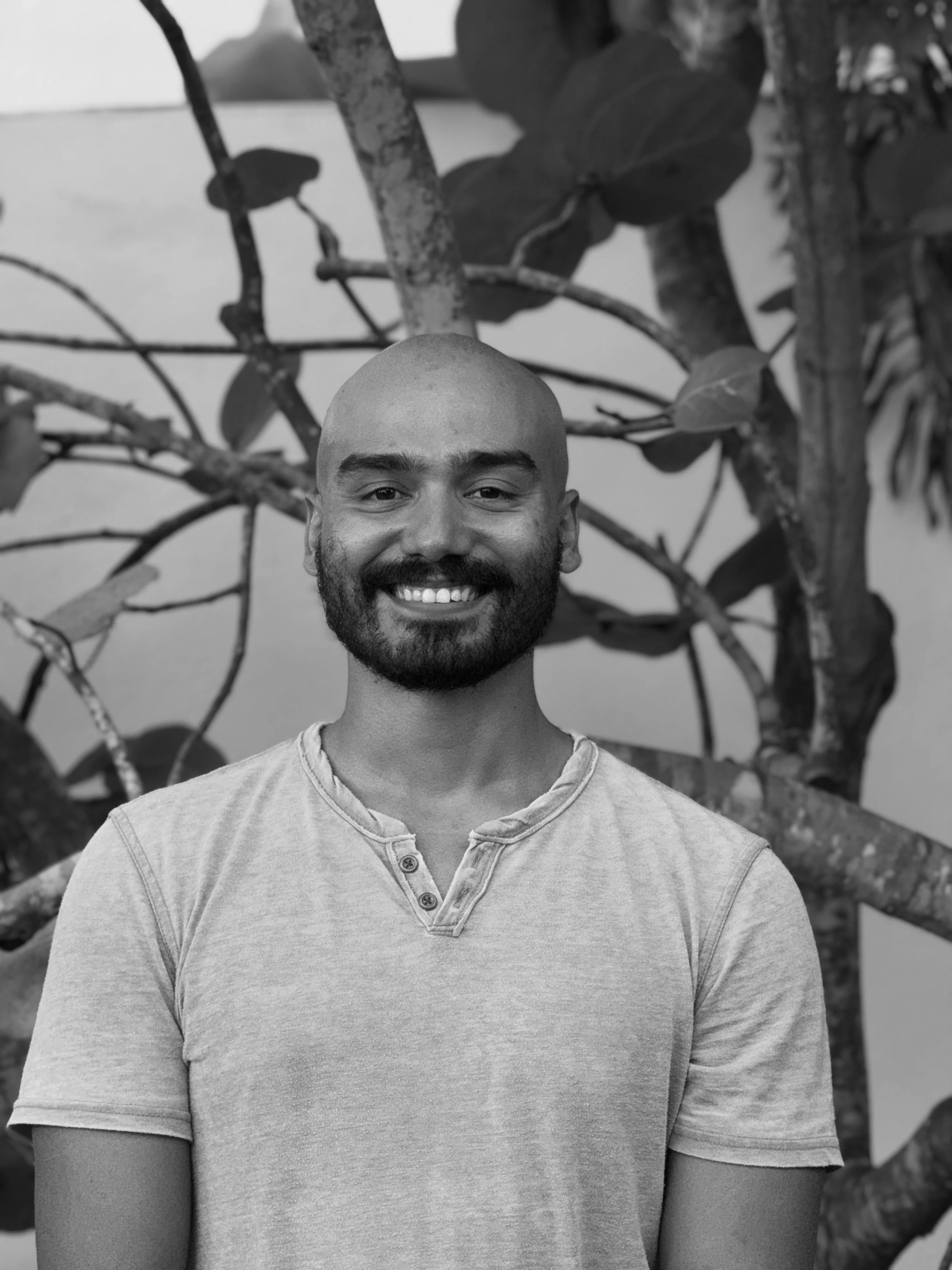 Cartoon illustration of a man with a beard and snorkeling goggles, smiling while leaning over the side of a boat in the ocean with a blue sky and clouds in the background.