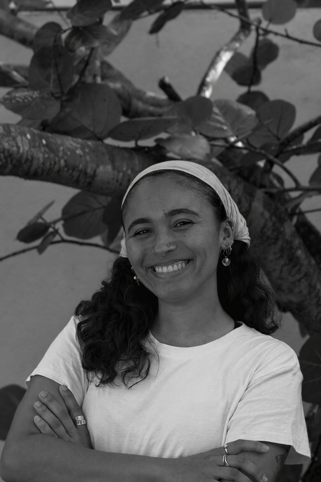 An animated drawing of a smiling man with glasses, a short beard, and short brown hair, outdoors with a blue sky, some clouds, greenery, and water in the background.