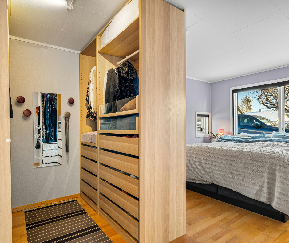 Organized bedroom closet with neatly folded clothes and hanging garments after professional organizing and cleaning service