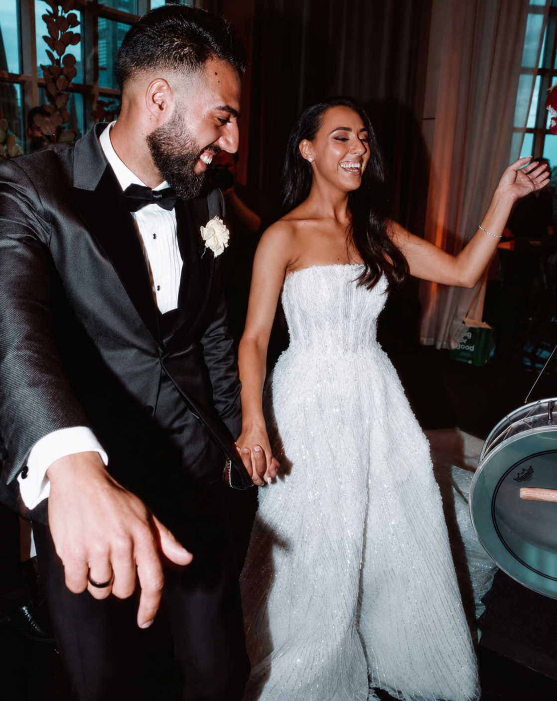 A bride and groom dancing and smiling at their wedding reception.