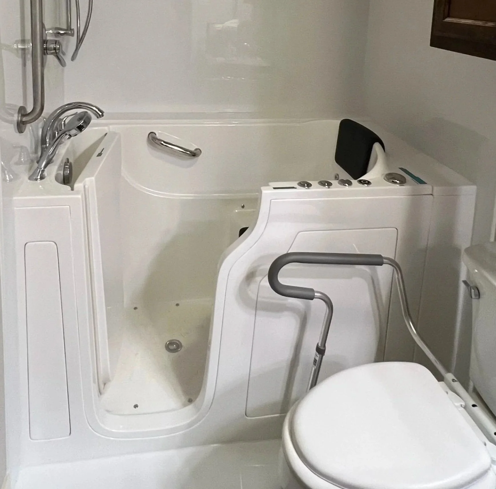 white walk-in bathtub for accessibility, with grab bars and a slide bar.