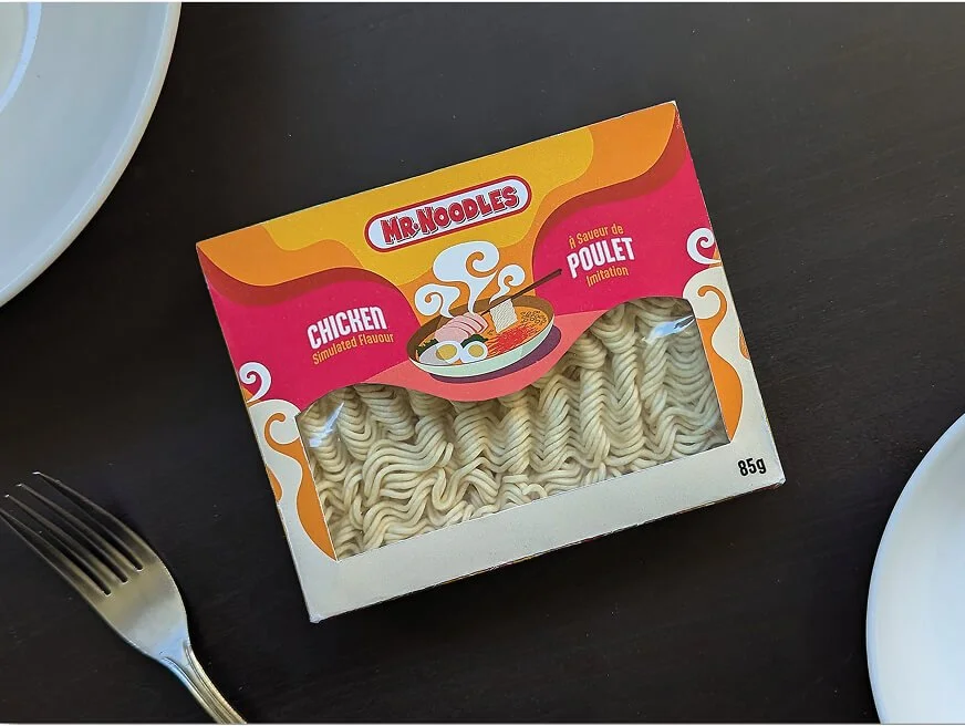 Noodle packaging on table surrounded by plates and cutlery