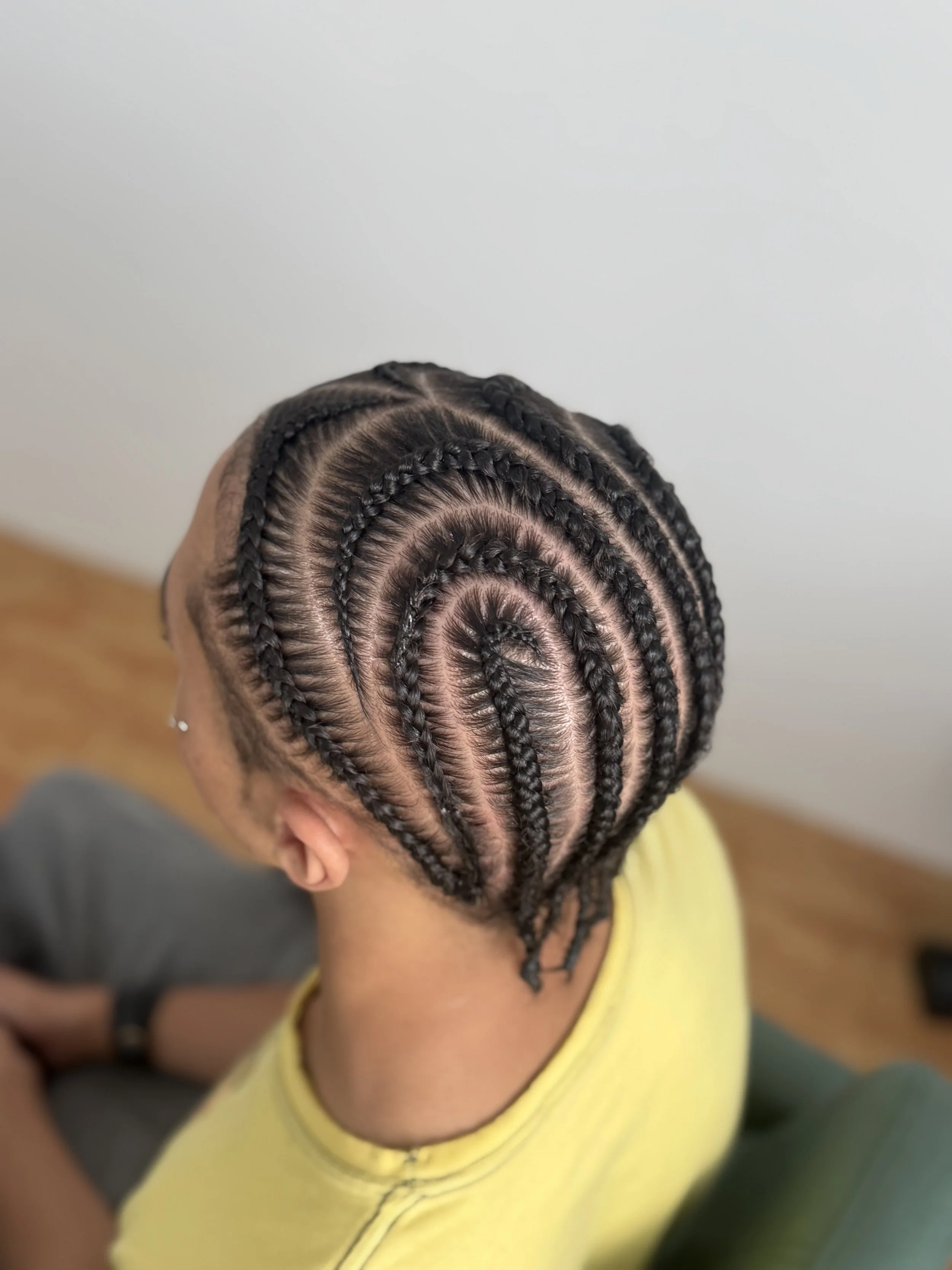 Top view of a person's head with intricately braided spiral design hairstyle.