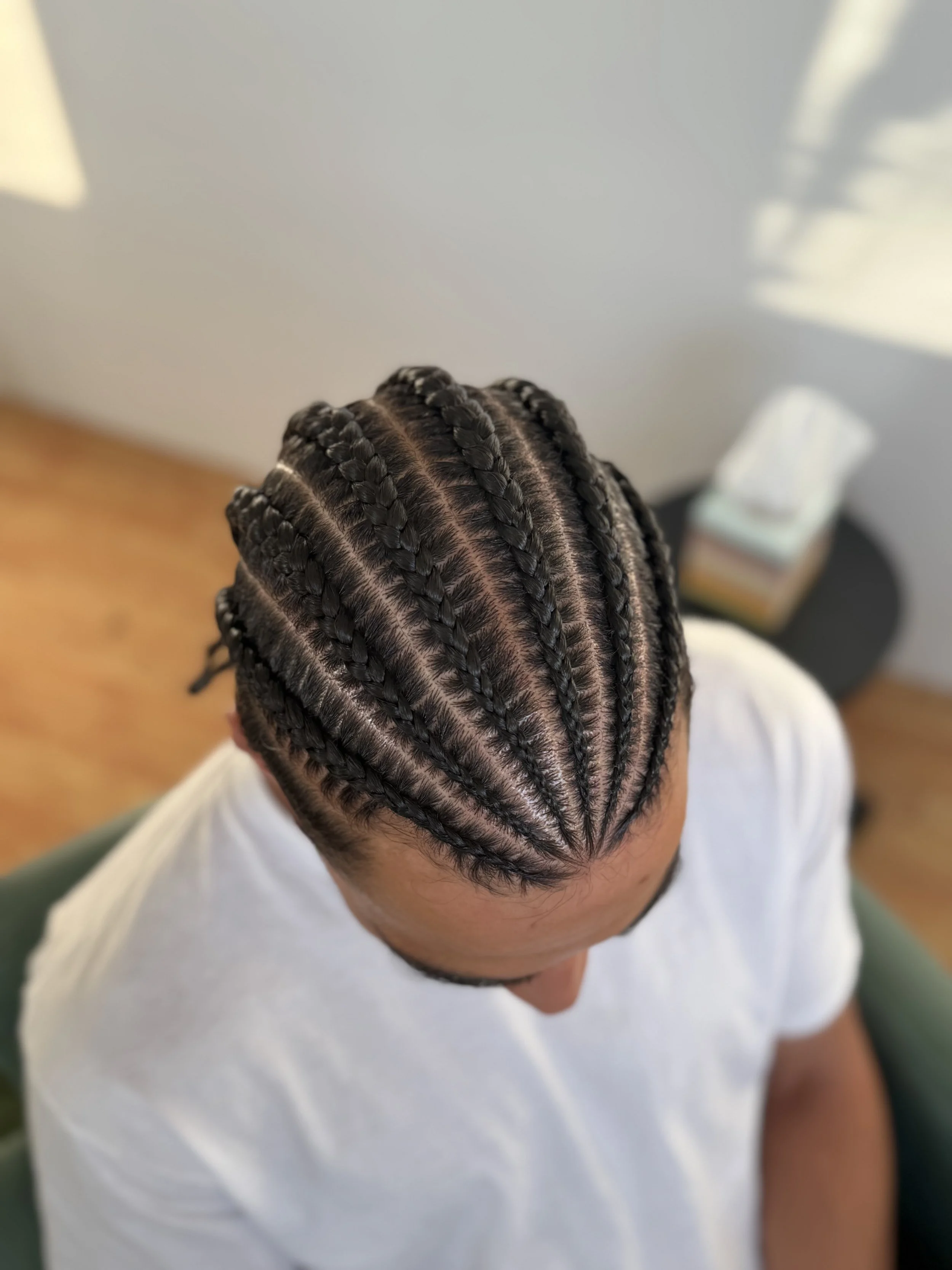 Top-down view of a person with freshly braided 6 cornrows hairstyle.