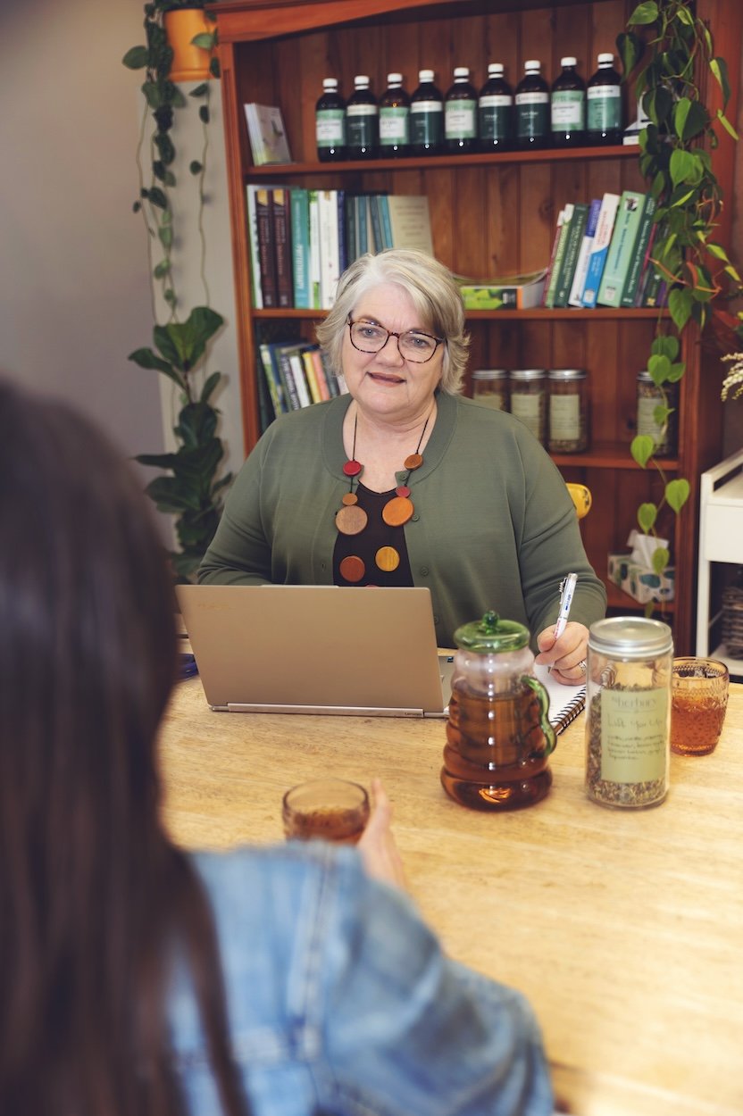 Naturopath consultation at The Herbary in Pukekohe, Auckland, with a practitioner meeting a client in a calm herbal clinic setting focused on personalised natural health care.