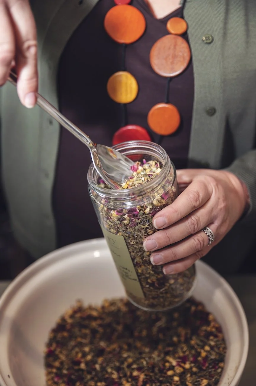 Preparing dried herbal tea blend at The Herbary in Pukekohe, Auckland, showcasing custom herbal medicine and naturopathic care.