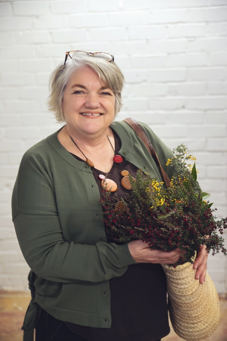 Naturopath from The Herbary in Pukekohe, Auckland holding fresh flowers and greenery, representing herbal medicine, natural health care, and personalised naturopathic support.