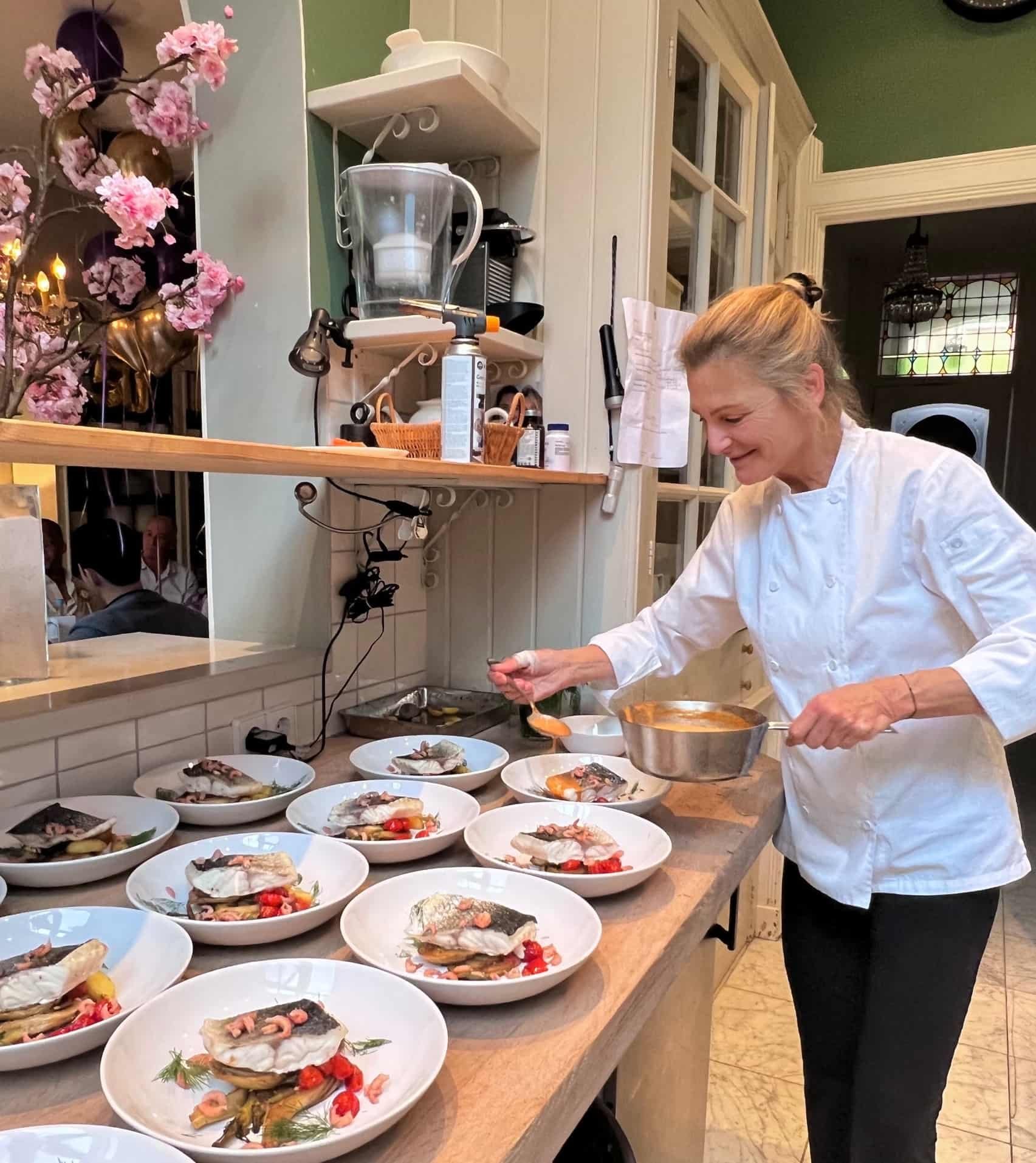 Chef Adrienne preparing and plating seasonal dishes in her home kitchen in Amsterdam.