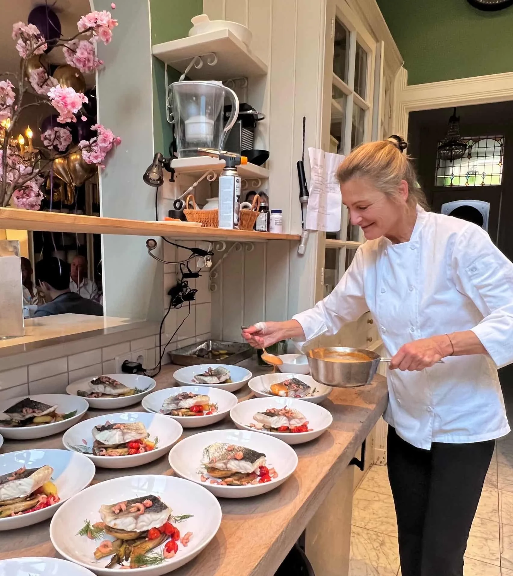 Chef Adrienne preparing and plating seasonal dishes in her home kitchen in Amsterdam for an intimate private dining experience – privé chef Amsterdam.